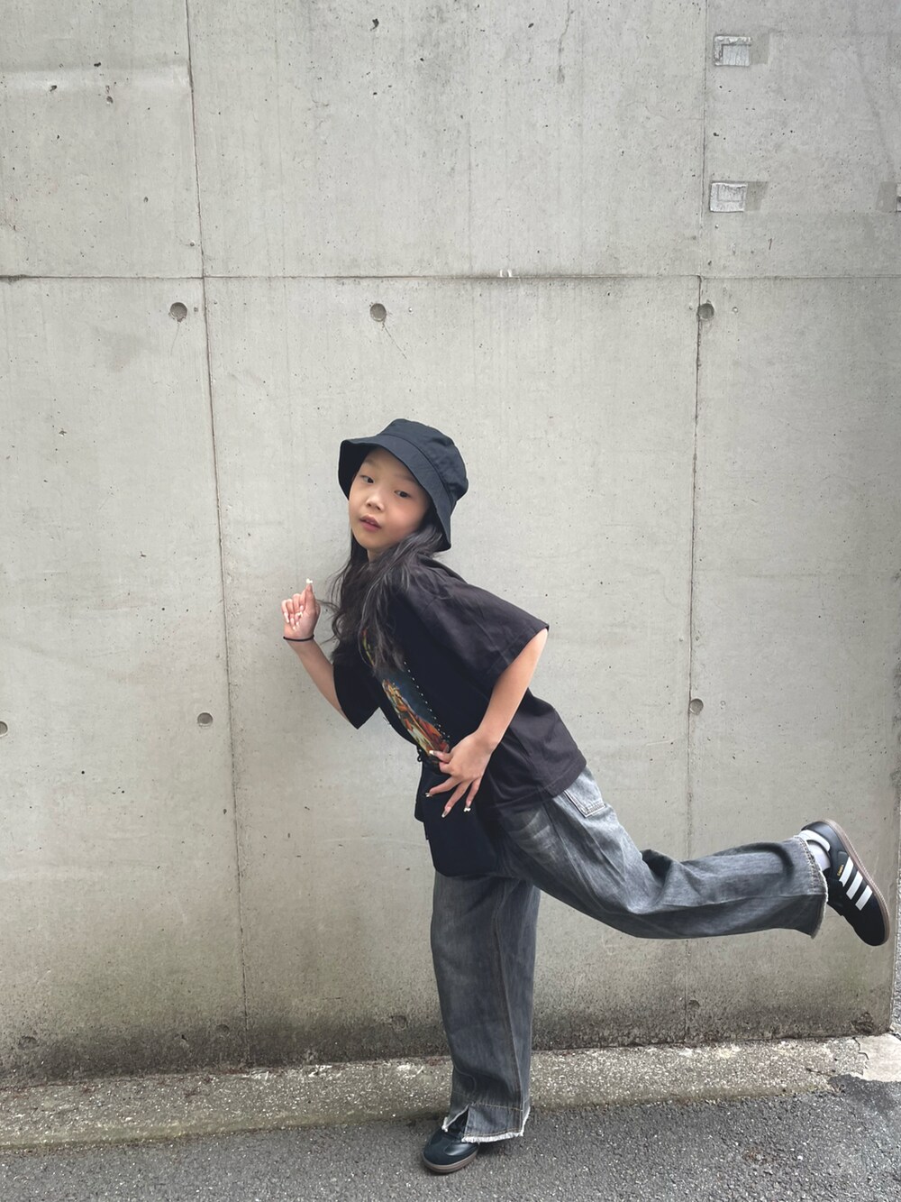 グレー系のデニムパンツ、ブラック系のスニーカー、ブラック系のTシャツ/カットソーを着用したキッズの春コーディネートの4枚目の写真