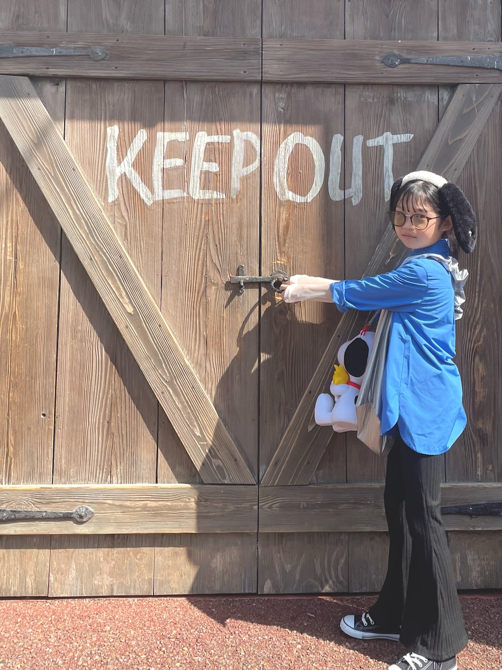 ブルー系のシャツ/ブラウス、シルバー系のショルダーバッグ、ブラック系のスニーカーを着用したキッズの春コーディネートの2枚目の写真