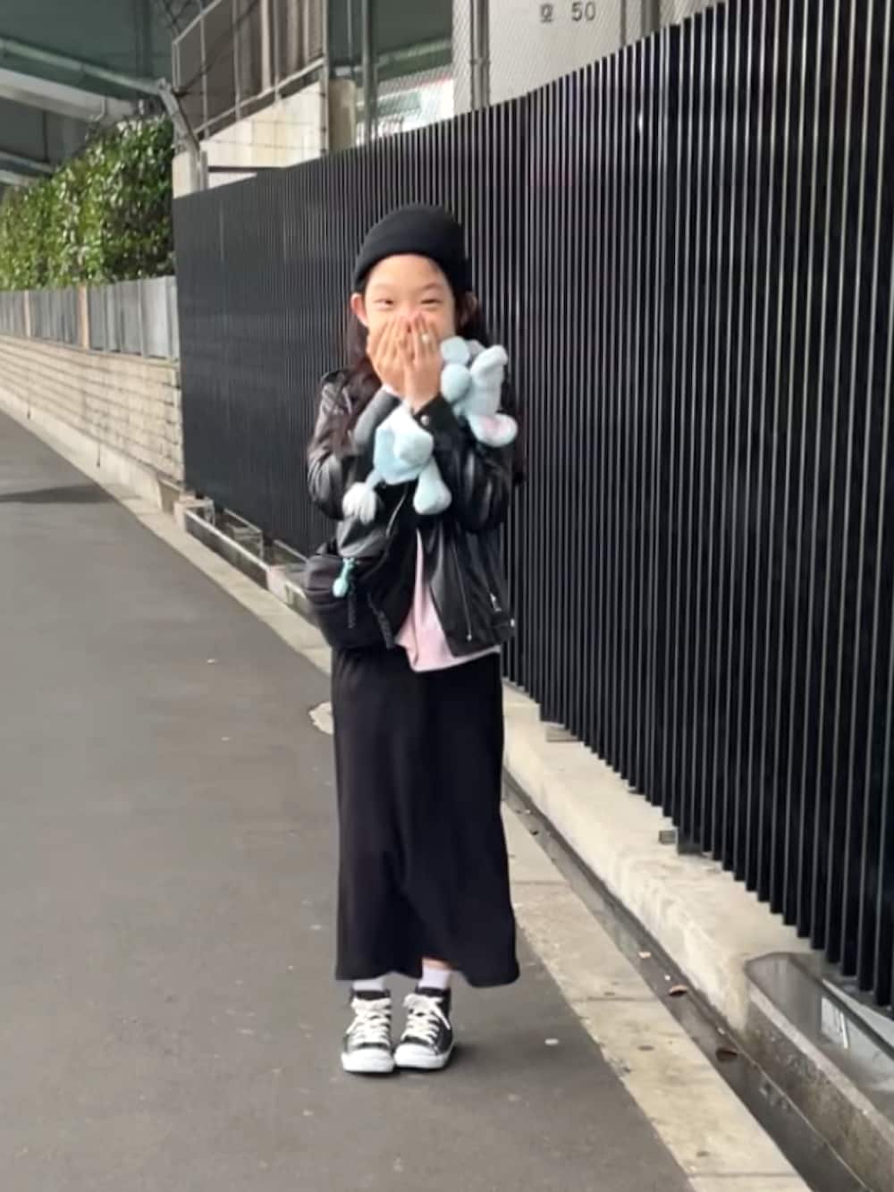 ブラック系のスカート、ブラック系のスニーカー、ブラック系のライダースジャケットを着用したキッズの春コーディネートの2枚目の写真