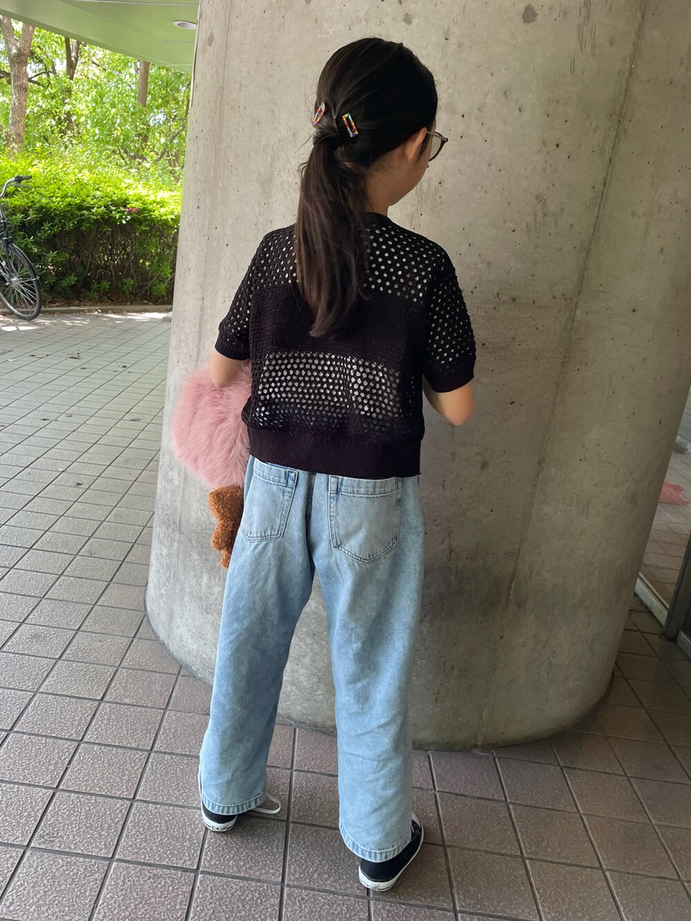 ブルー系のデニムパンツ、ブラック系のカーディガン/ボレロ、ピンク系のバッグを着用したキッズの春コーディネートの2枚目の写真