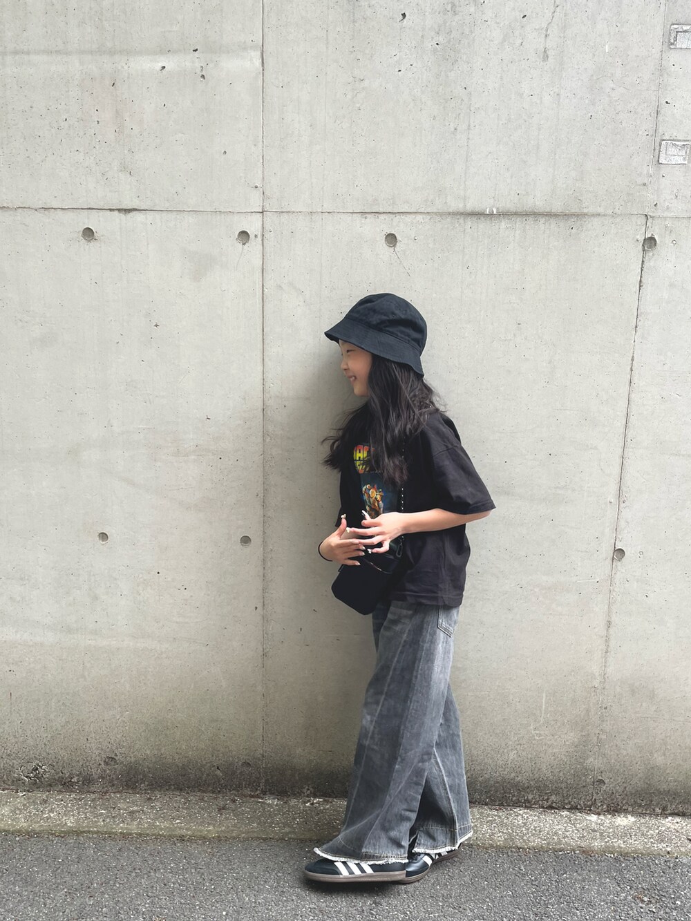 グレー系のデニムパンツ、ブラック系のスニーカー、ブラック系のTシャツ/カットソーを着用したキッズの春コーディネートの2枚目の写真