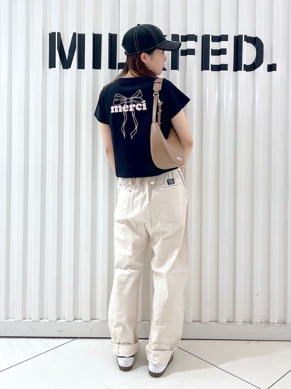 ホワイト系のその他パンツ、ブラック系のTシャツ/カットソー、ホワイト系のハンドバッグを着用したレディースの夏コーディネートの2枚目の写真