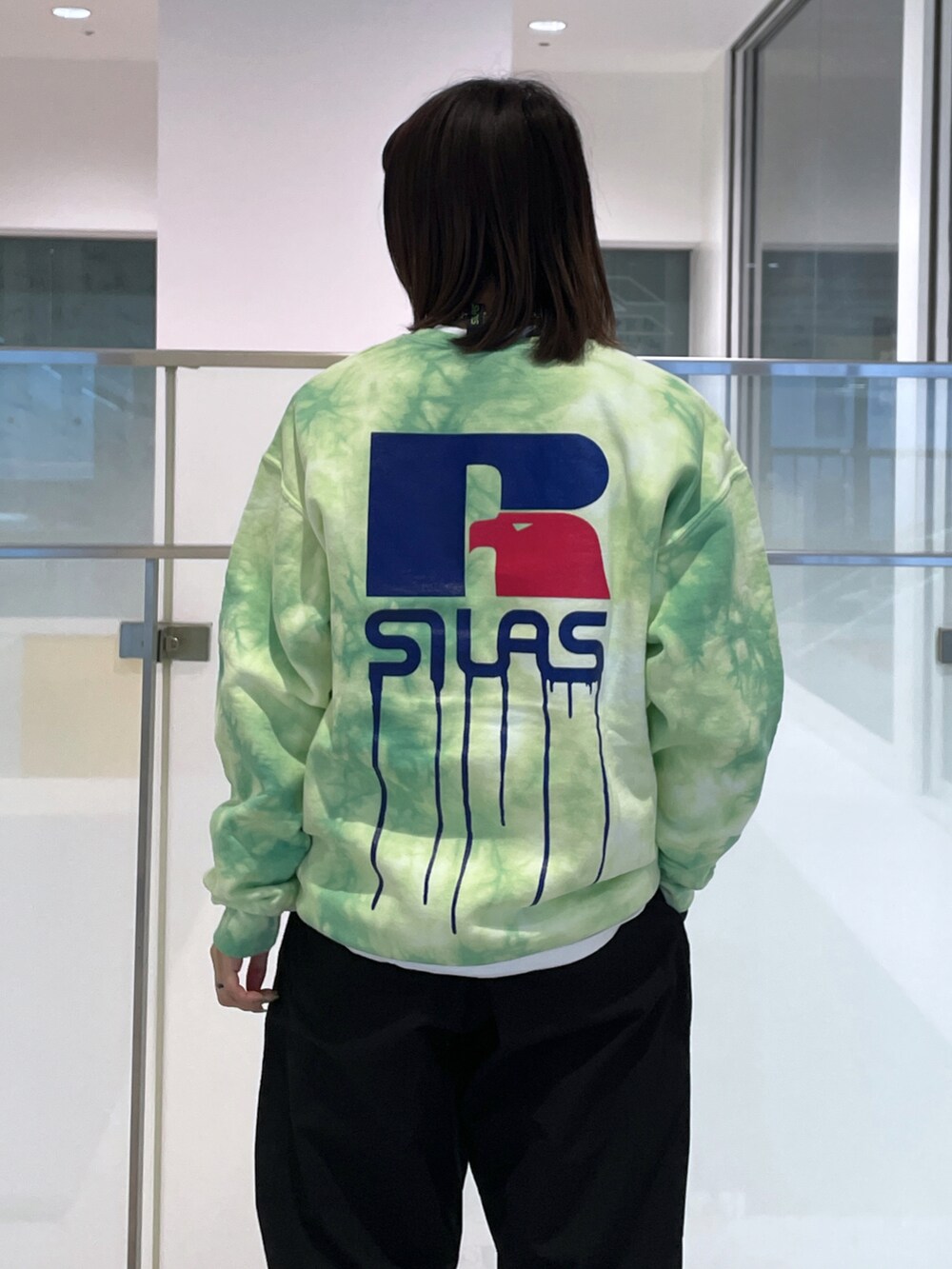 ブラック系のその他パンツ、グリーン系のスウェット、レッド系のバックパック/リュックを着用したレディースの春コーディネートの3枚目の写真