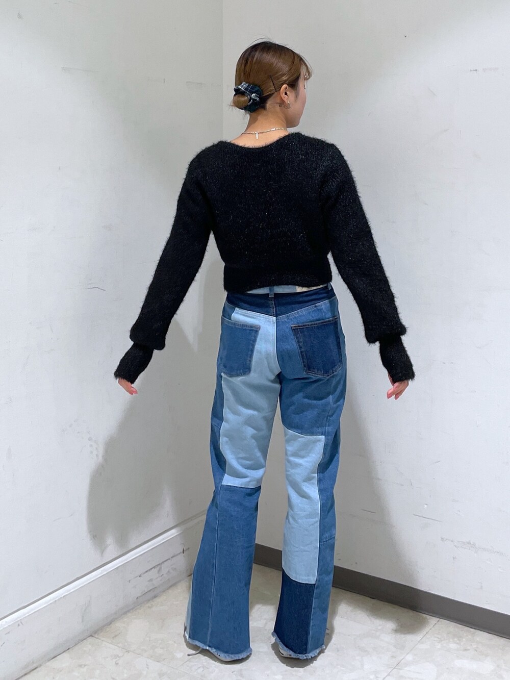 ブルー系のデニムパンツ、ブラック系のカーディガン/ボレロ、ブラック系のショルダーバッグを着用したレディースの冬コーディネートの4枚目の写真