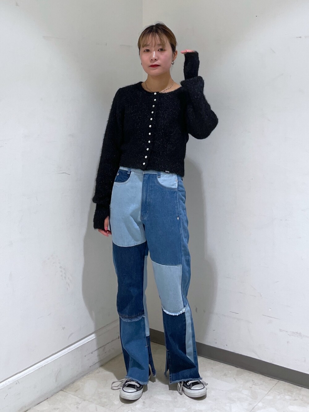 ブルー系のデニムパンツ、ブラック系のカーディガン/ボレロ、ブラック系のショルダーバッグを着用したレディースの冬コーディネートの3枚目の写真