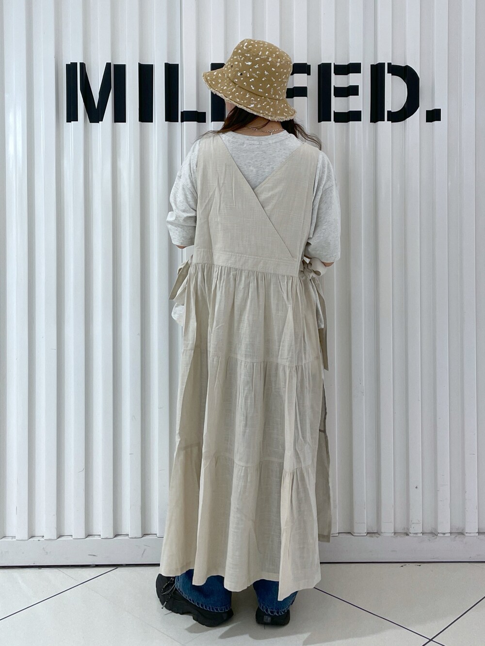 ブルー系のワンピース、ブラック系のデニムパンツ、ベージュ系のTシャツ/カットソーを着用したレディースの夏コーディネートの2枚目の写真