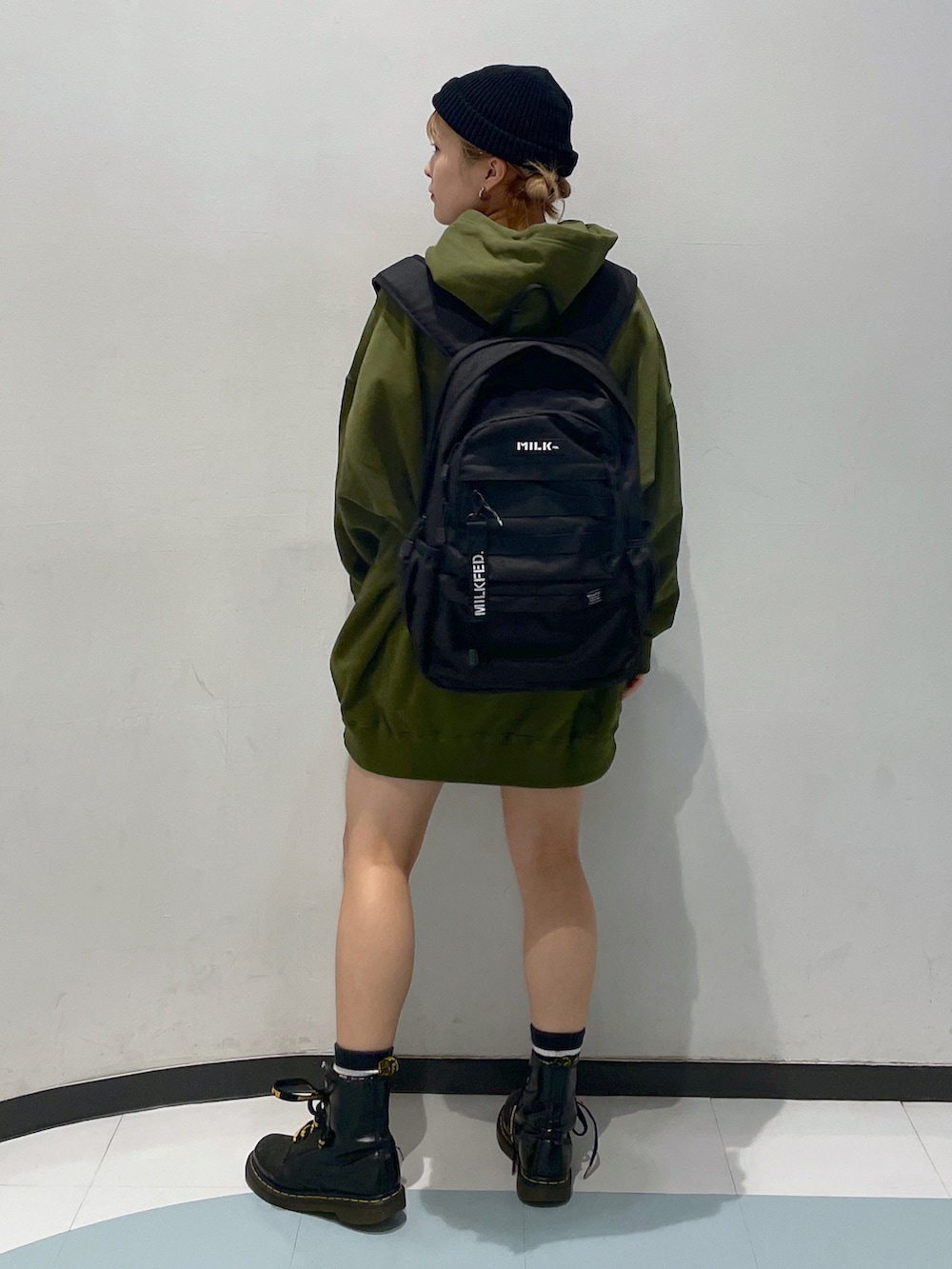 グリーン系のパーカー、ブラック系のバックパック/リュック、ブラック系のブーツを着用したレディースの秋コーディネートの2枚目の写真