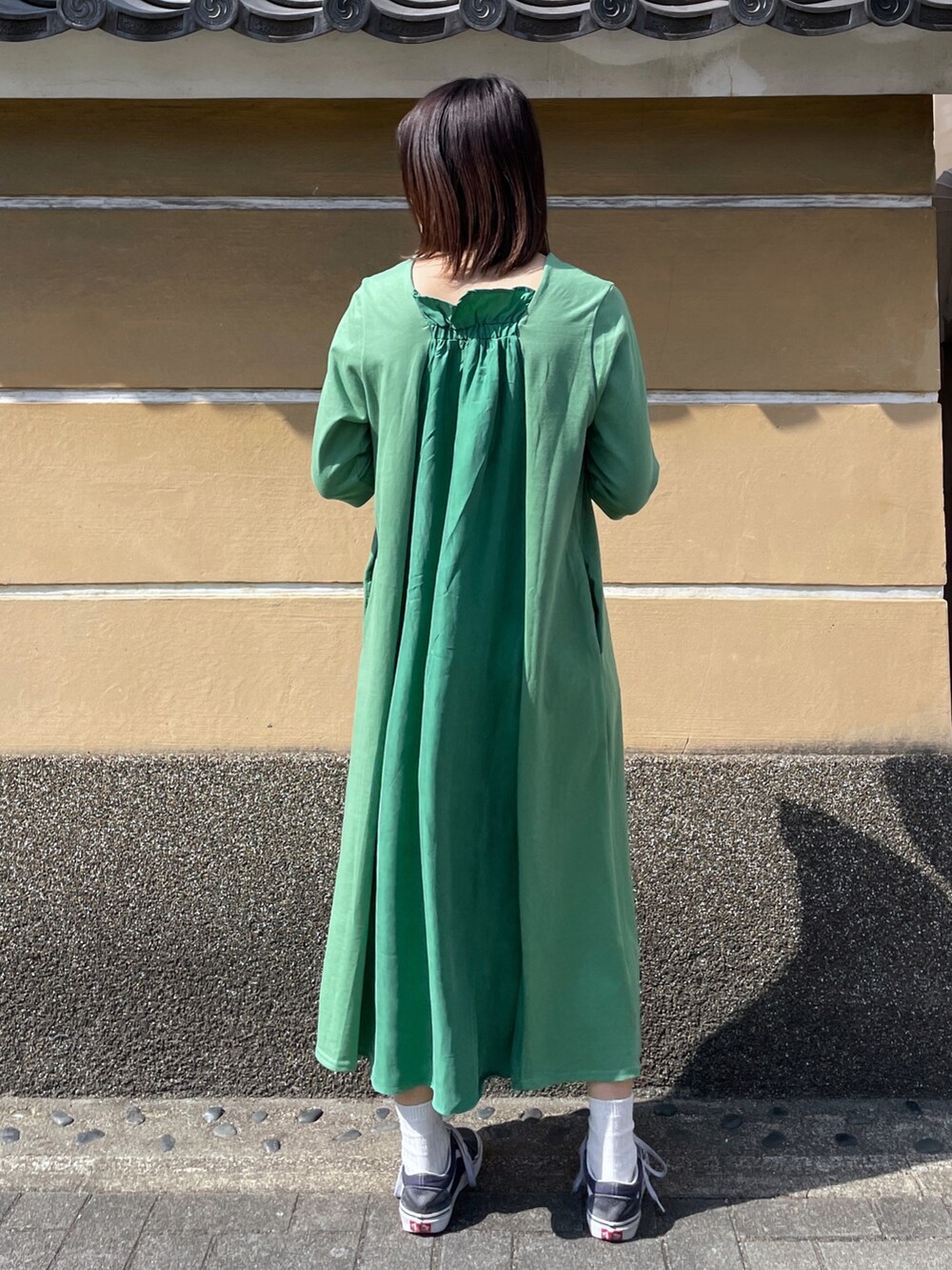 ホワイト系のショルダーバッグ、グリーン系のワンピースを着用したレディースの春コーディネートの2枚目の写真