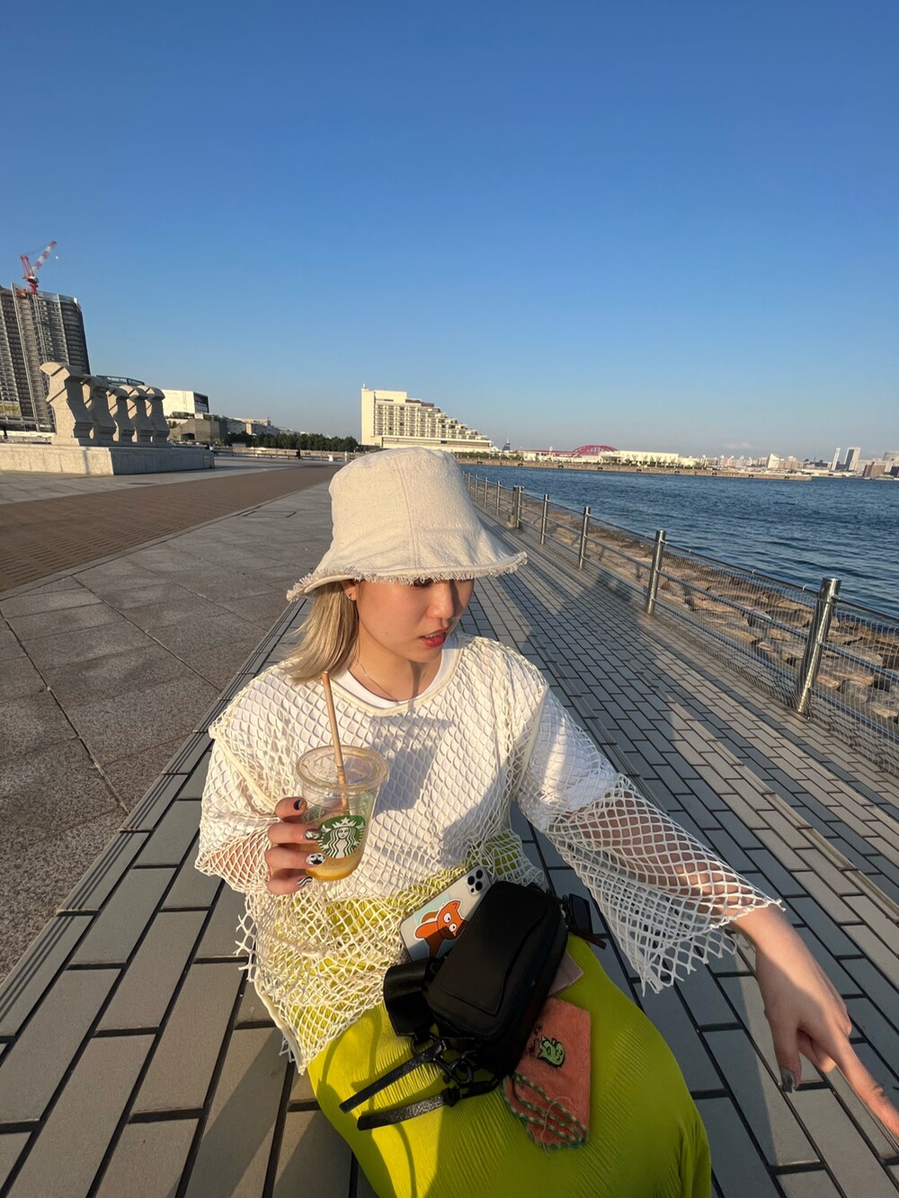 ベージュ系のTシャツ/カットソー、ブラック系のサンダル、ベージュ系のハットを着用したレディースの夏コーディネートの2枚目の写真