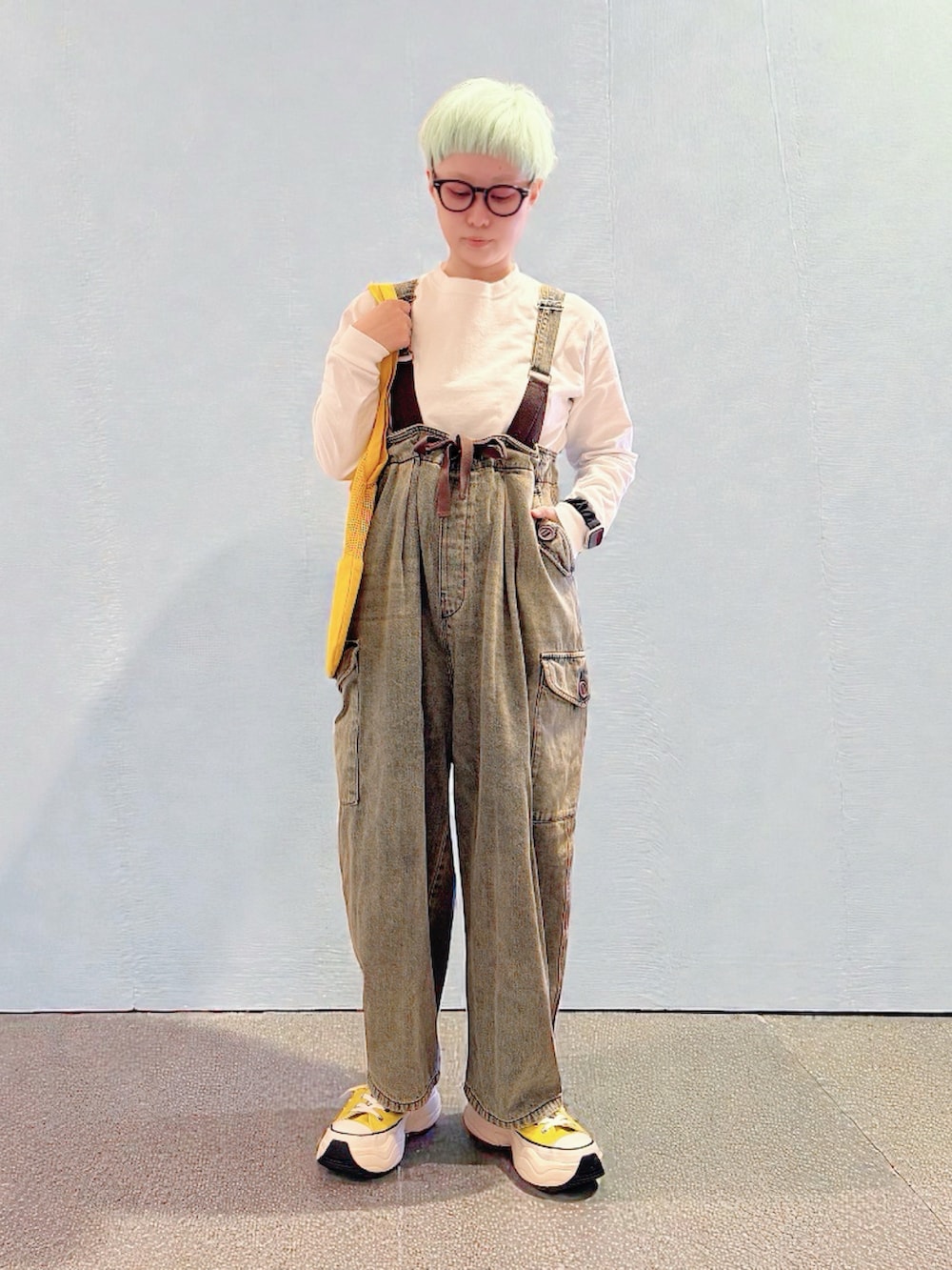 イエロー系のスニーカー、ブラウン系のデニムパンツ、イエロー系のトートバッグを着用したレディースの冬コーディネートの4枚目の写真