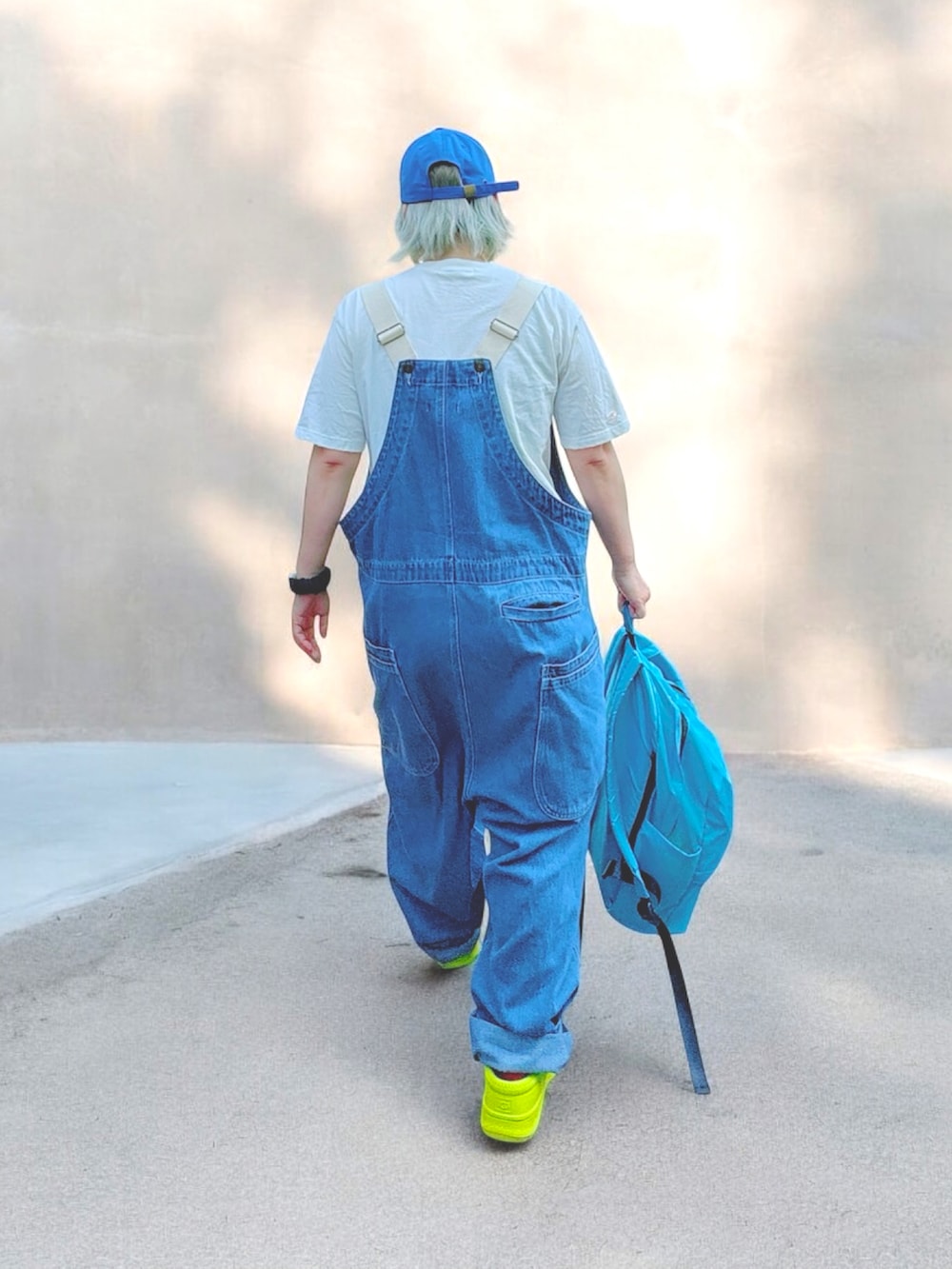 ブルー系のバックパック/リュック、ブルー系のサロペット/オーバーオール、グリーン系のスリッポンを着用したレディースの春コーディネートの2枚目の写真