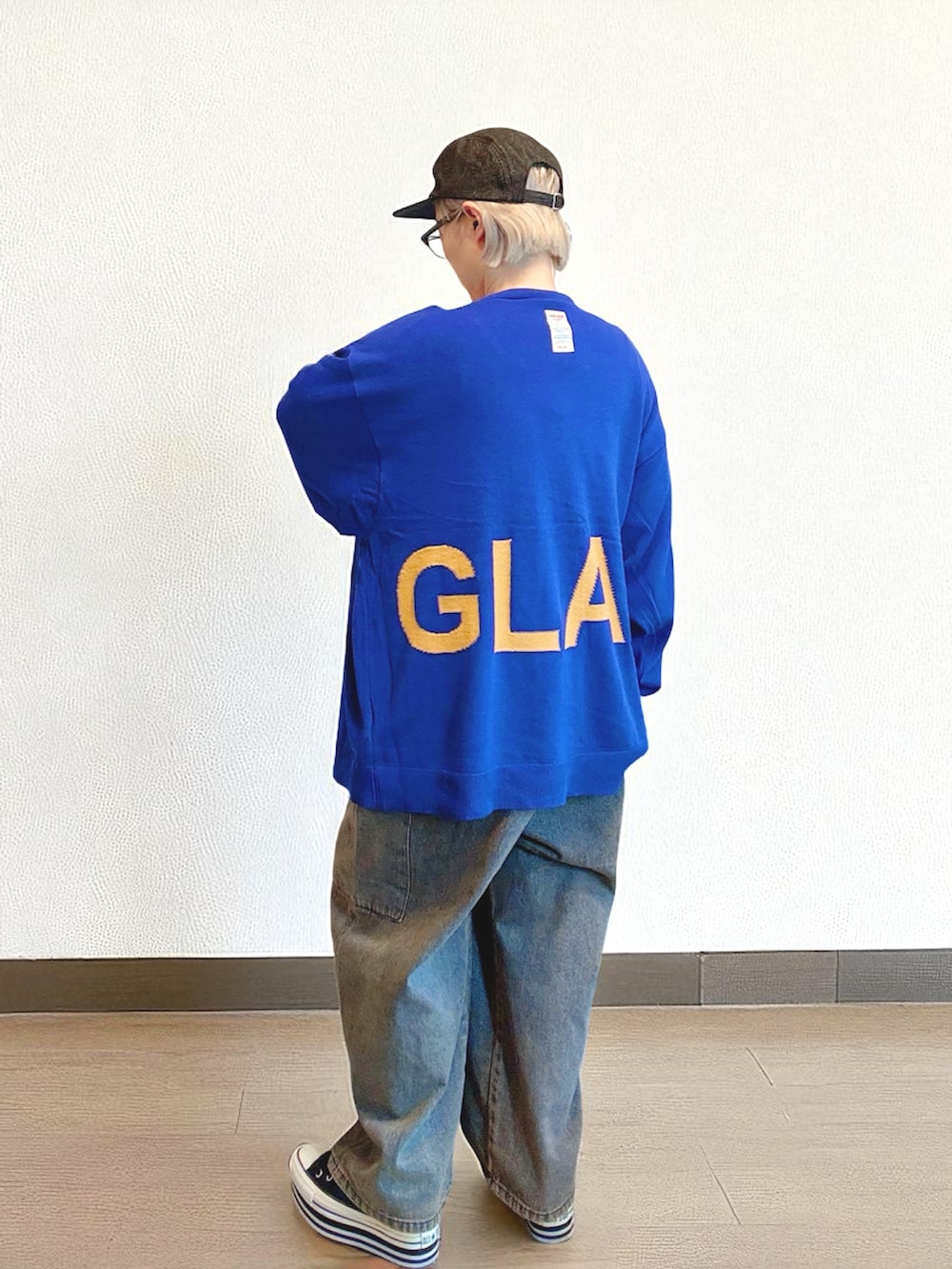 ブラウン系のデニムパンツ、ブルー系のカーディガン/ボレロ、ホワイト系のトップスを着用したレディースの秋コーディネートの2枚目の写真