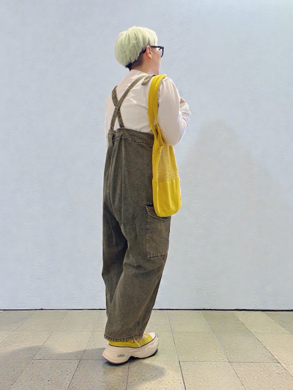 イエロー系のスニーカー、ブラウン系のデニムパンツ、イエロー系のトートバッグを着用したレディースの冬コーディネートの3枚目の写真