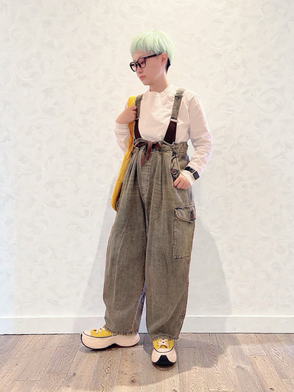 イエロー系のスニーカー、ブラウン系のデニムパンツ、イエロー系のトートバッグを着用したレディースの冬コーディネートの2枚目の写真