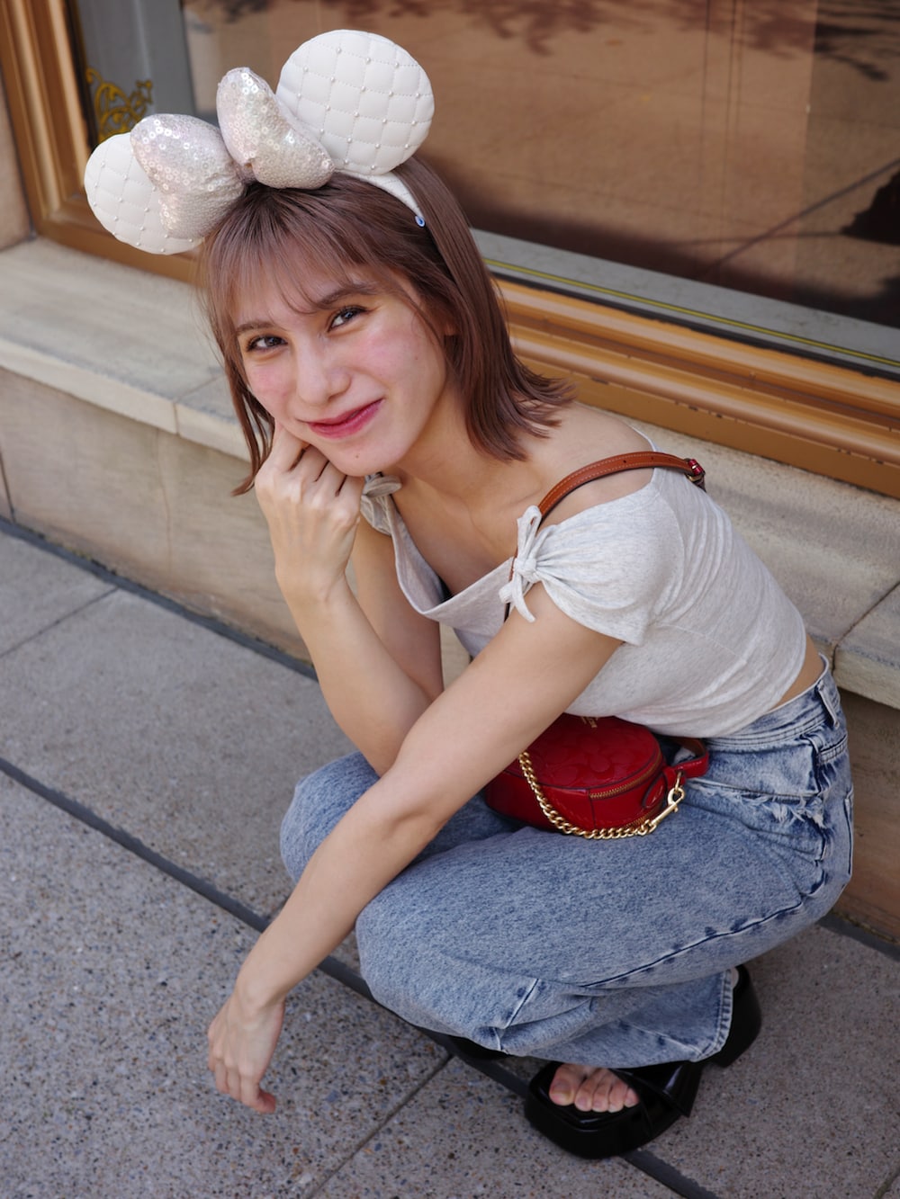 ブルー系のデニムパンツ、ブラック系のサンダル、グレー系のTシャツ/カットソーを着用したレディースの秋コーディネートの4枚目の写真