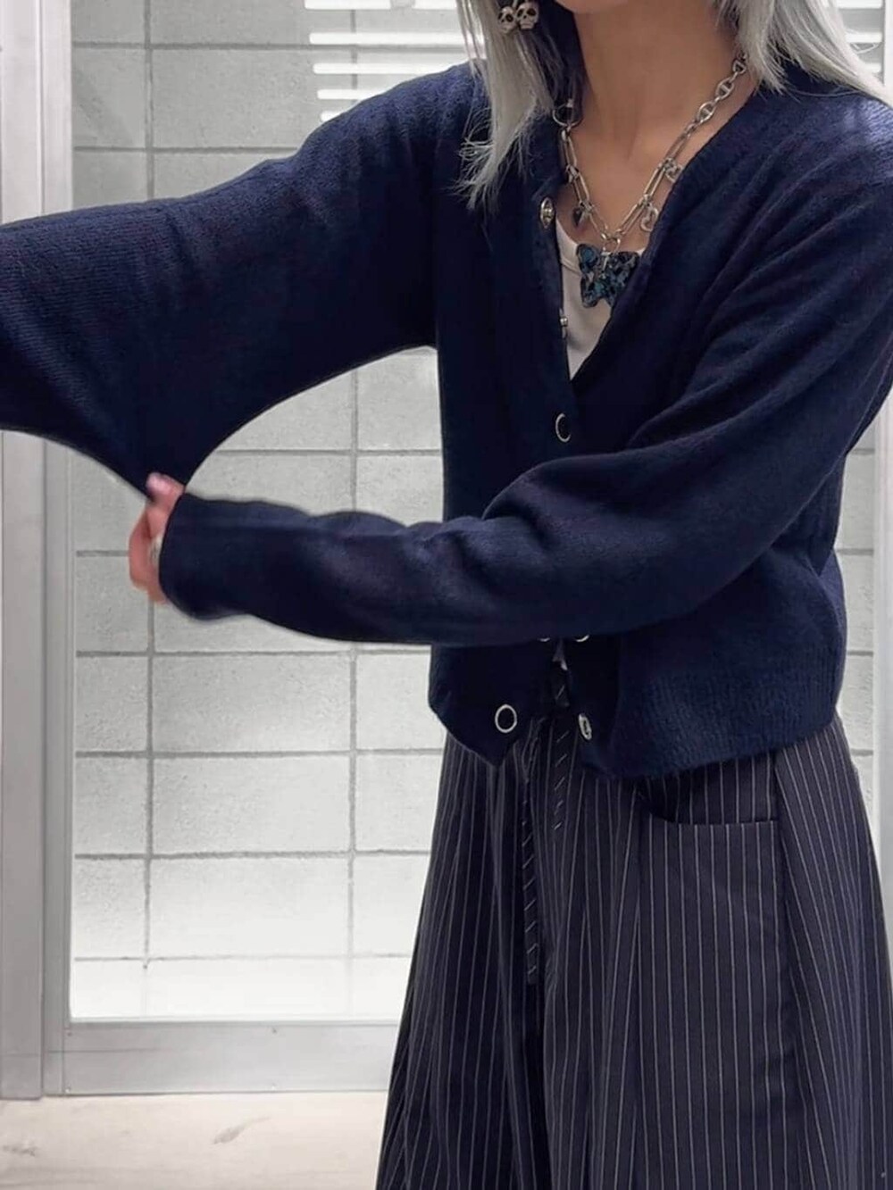ホワイト系のTシャツ/カットソー、ブラック系のブーツ、ブルー系のスラックスを着用したレディースの冬コーディネートの5枚目の写真
