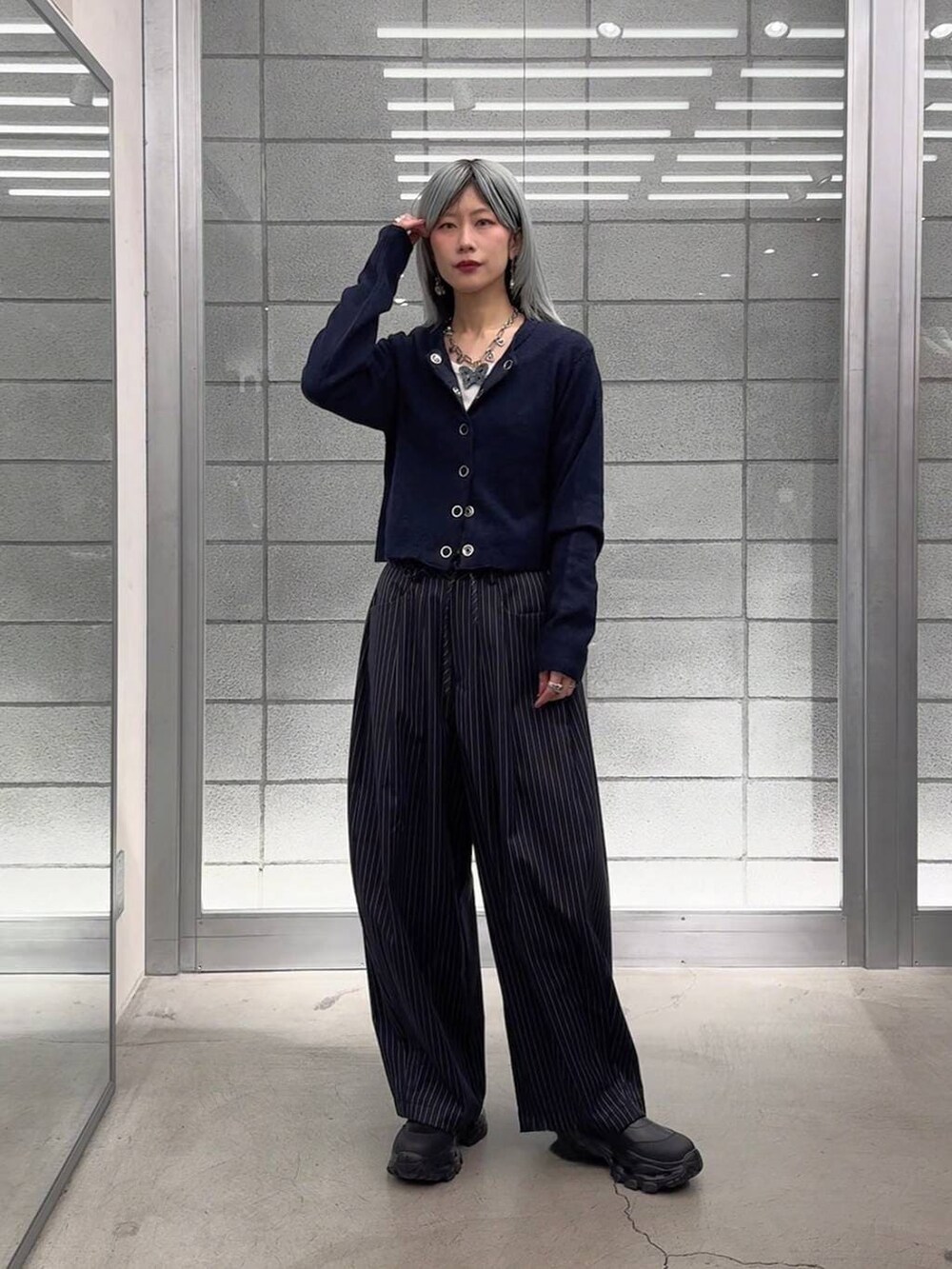 ホワイト系のTシャツ/カットソー、ブラック系のブーツ、ブルー系のスラックスを着用したレディースの冬コーディネートの8枚目の写真