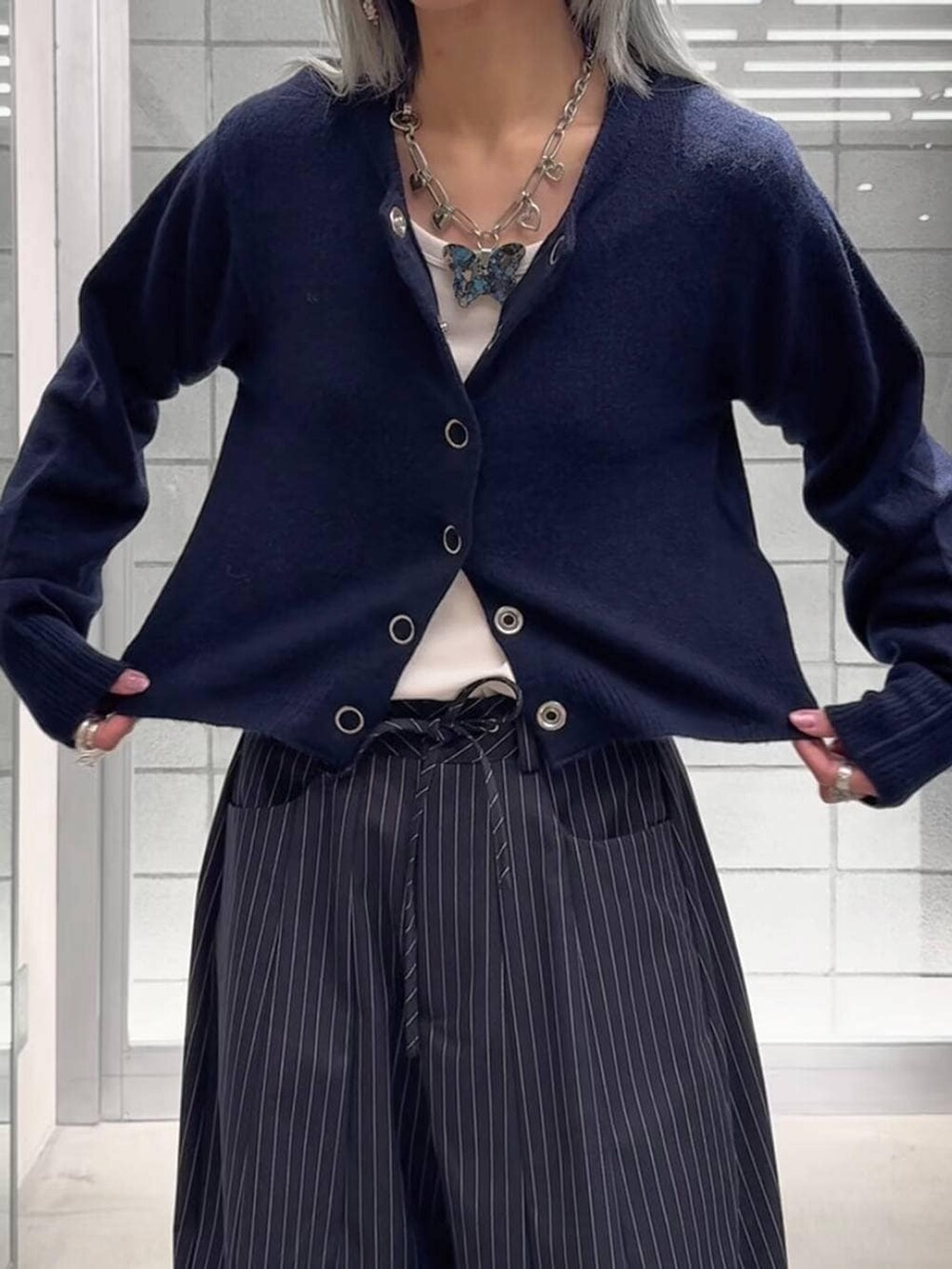 ホワイト系のTシャツ/カットソー、ブラック系のブーツ、ブルー系のスラックスを着用したレディースの冬コーディネートの4枚目の写真