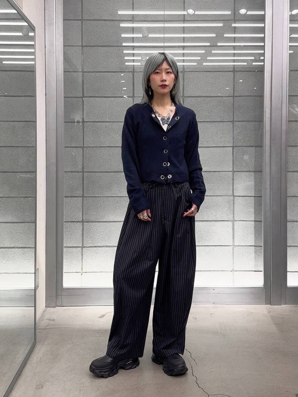 ホワイト系のTシャツ/カットソー、ブラック系のブーツ、ブルー系のスラックスを着用したレディースの冬コーディネートの9枚目の写真