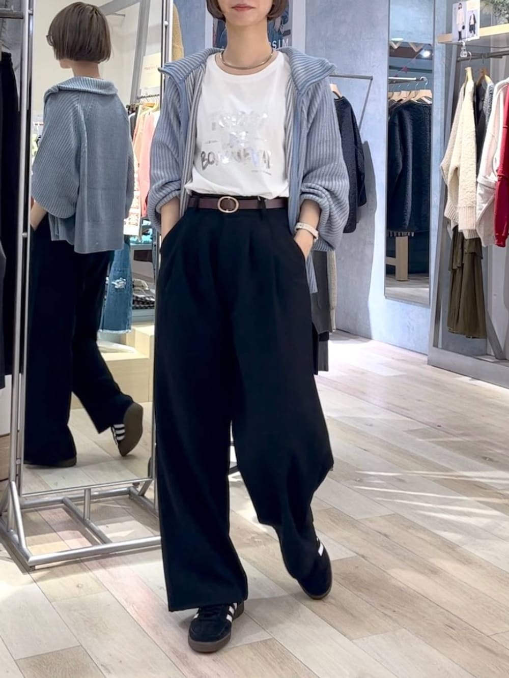 ブラック系のスニーカー、ブルー系のカーディガン/ボレロ、ホワイト系のTシャツ/カットソーを着用したレディースの秋コーディネートの2枚目の写真