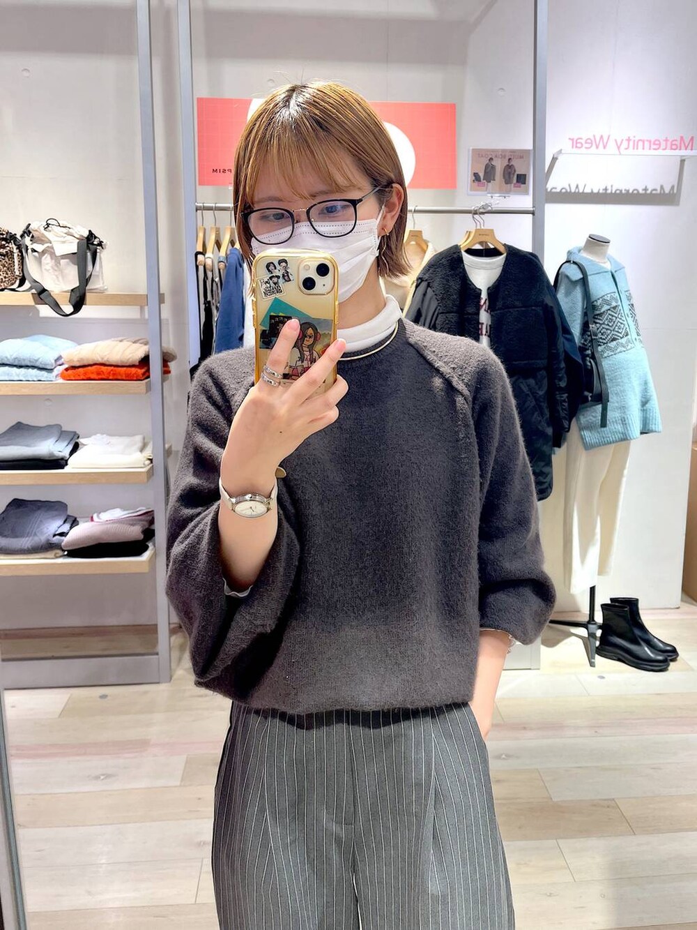 グレー系のニット/セーター、ホワイト系のTシャツ/カットソー、グレー系のその他パンツを着用したレディースの秋コーディネートの2枚目の写真