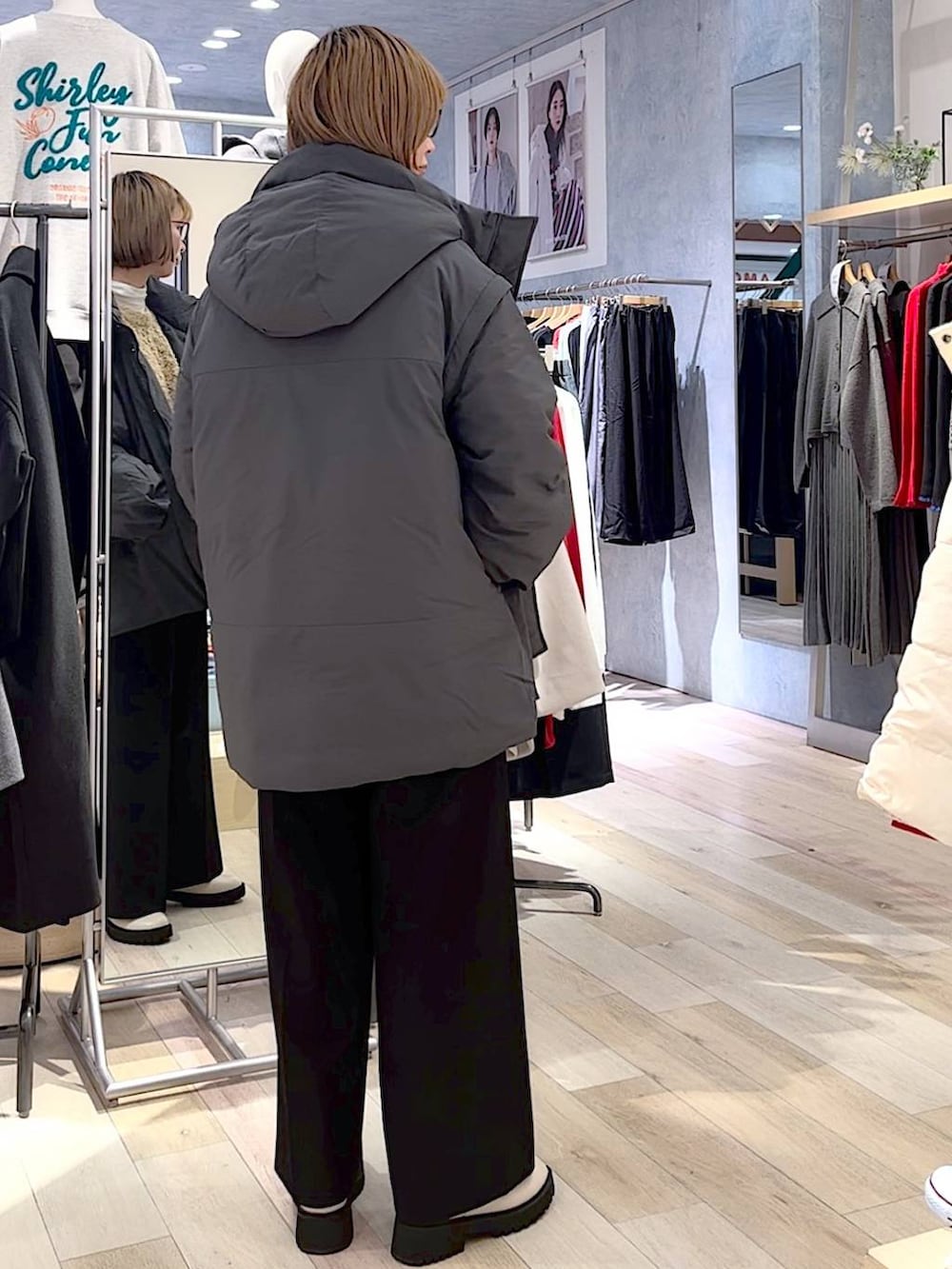 グレー系のダウンジャケット/コート、ホワイト系のブーツ、ブラック系のスラックスを着用したレディースの秋コーディネートの3枚目の写真