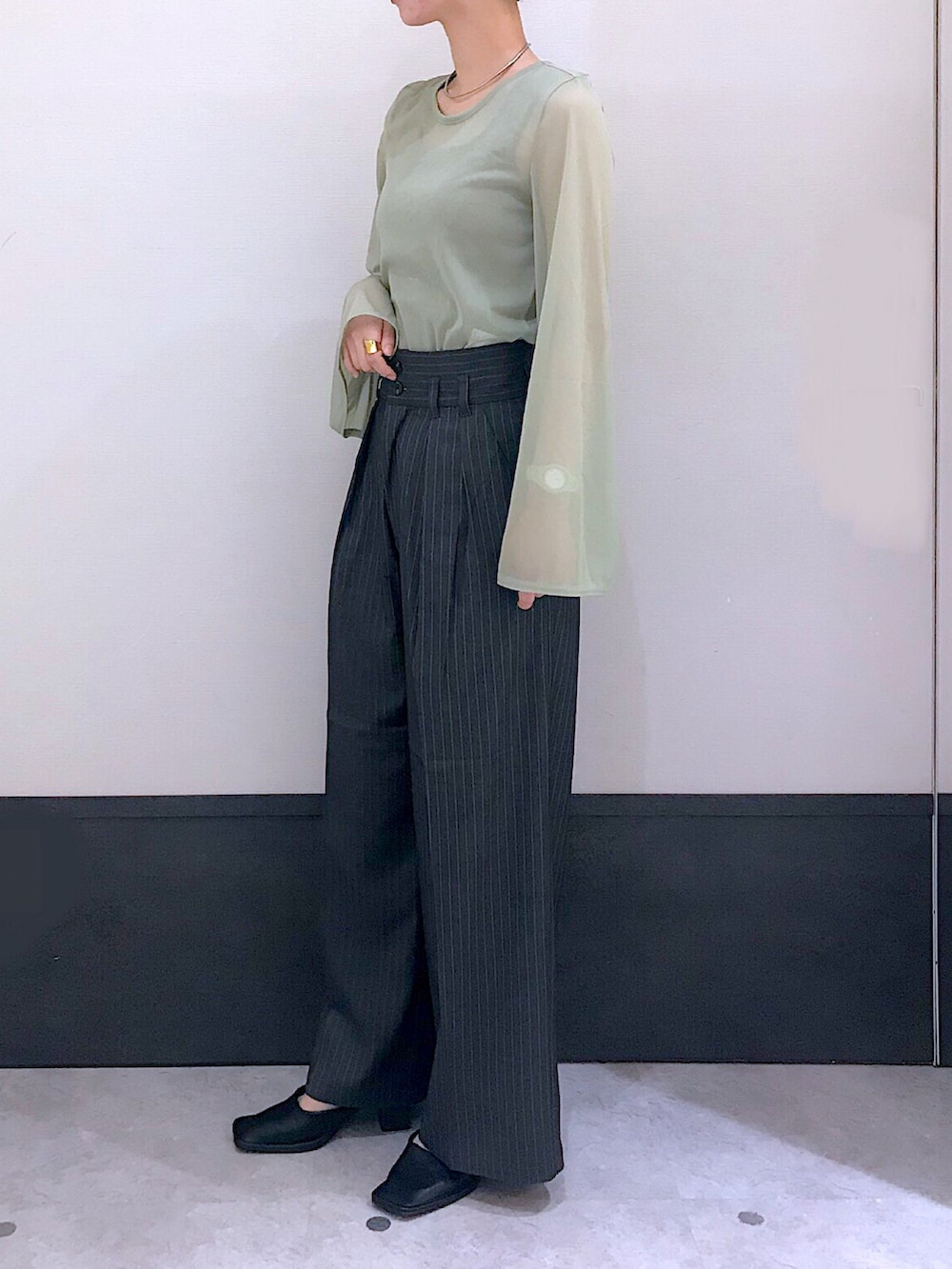 グリーン系のTシャツ/カットソー、グレー系のその他パンツ、ブラック系のパンプスを着用したレディースの秋コーディネートの2枚目の写真