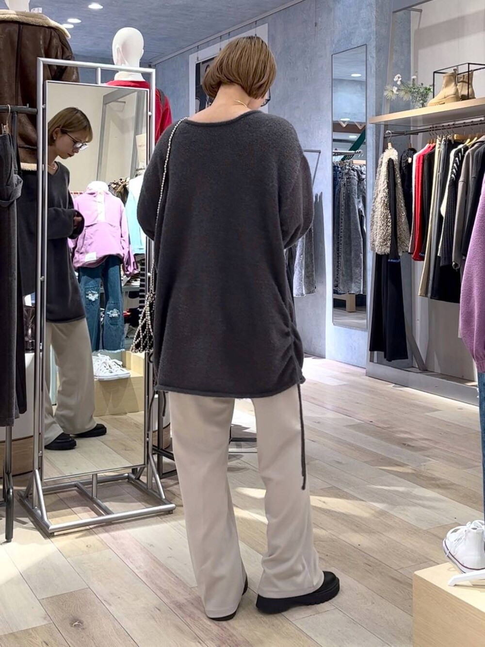 ブラック系のブーツ、ベージュ系のその他パンツ、グレー系のショルダーバッグを着用したレディースの秋コーディネートの3枚目の写真