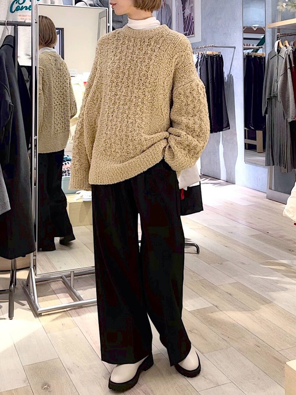 グレー系のダウンジャケット/コート、ホワイト系のブーツ、ブラック系のスラックスを着用したレディースの秋コーディネートの4枚目の写真