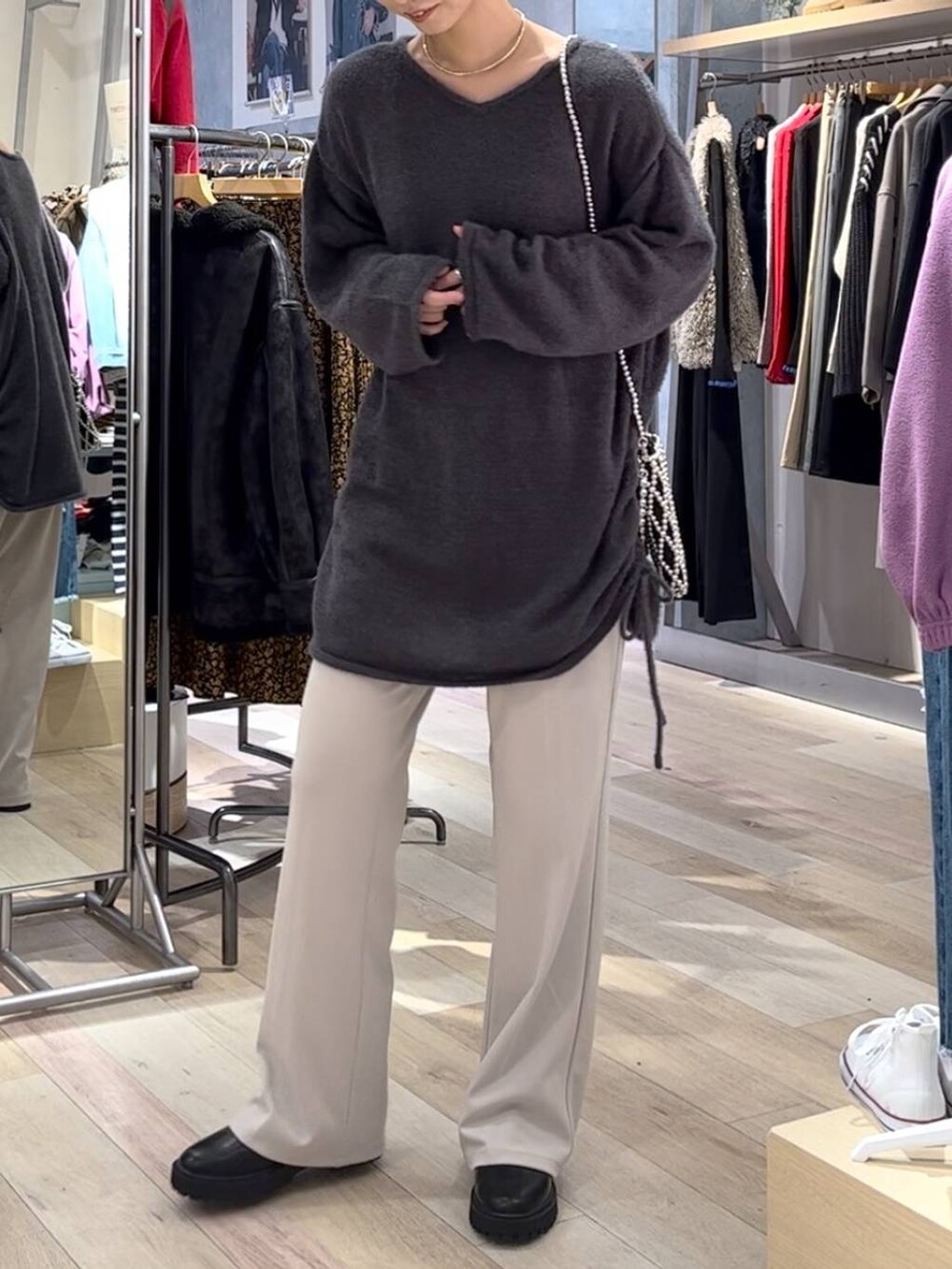 ブラック系のブーツ、ベージュ系のその他パンツ、グレー系のショルダーバッグを着用したレディースの秋コーディネートの2枚目の写真