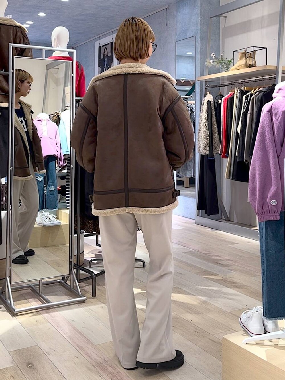 ブラック系のブーツ、ベージュ系のその他パンツ、ブルー系のニット/セーターを着用したレディースの秋コーディネートの3枚目の写真