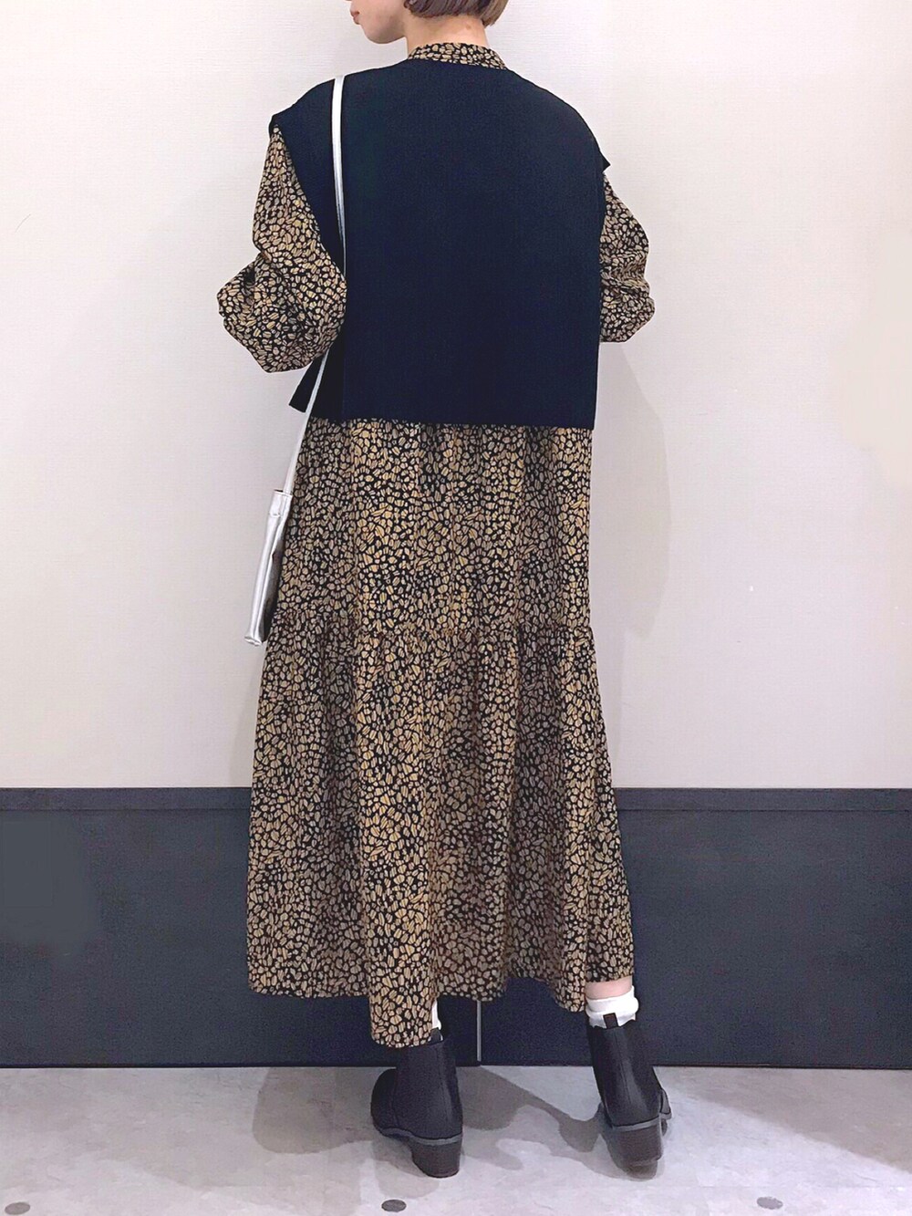 ブラック系のベスト、シルバー系のショルダーバッグ、ブラウン系のワンピース/ドレスを着用したレディースの秋コーディネートの2枚目の写真