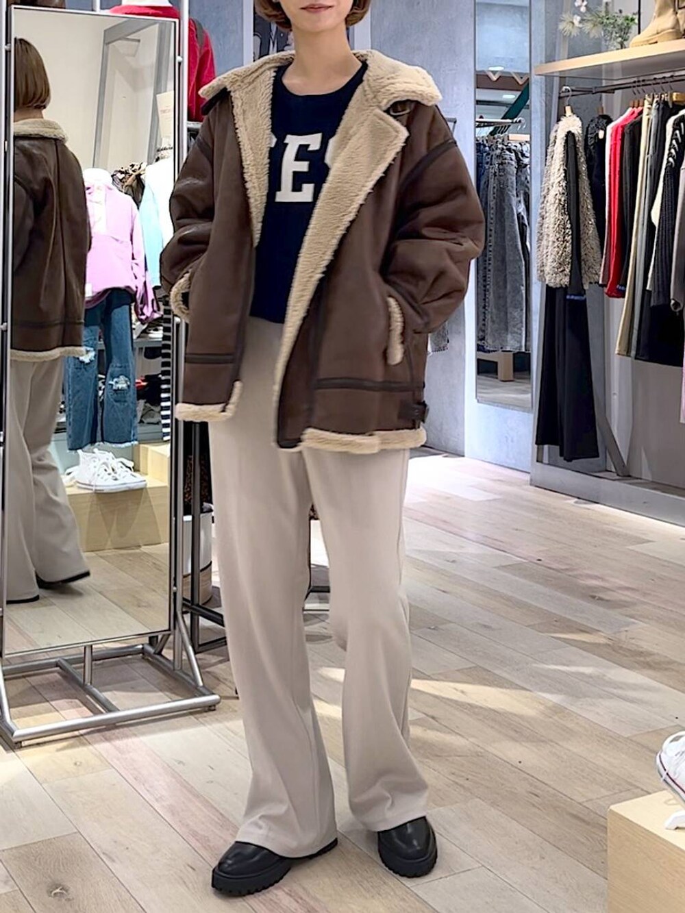 ブラック系のブーツ、ベージュ系のその他パンツ、ブルー系のニット/セーターを着用したレディースの秋コーディネートの2枚目の写真