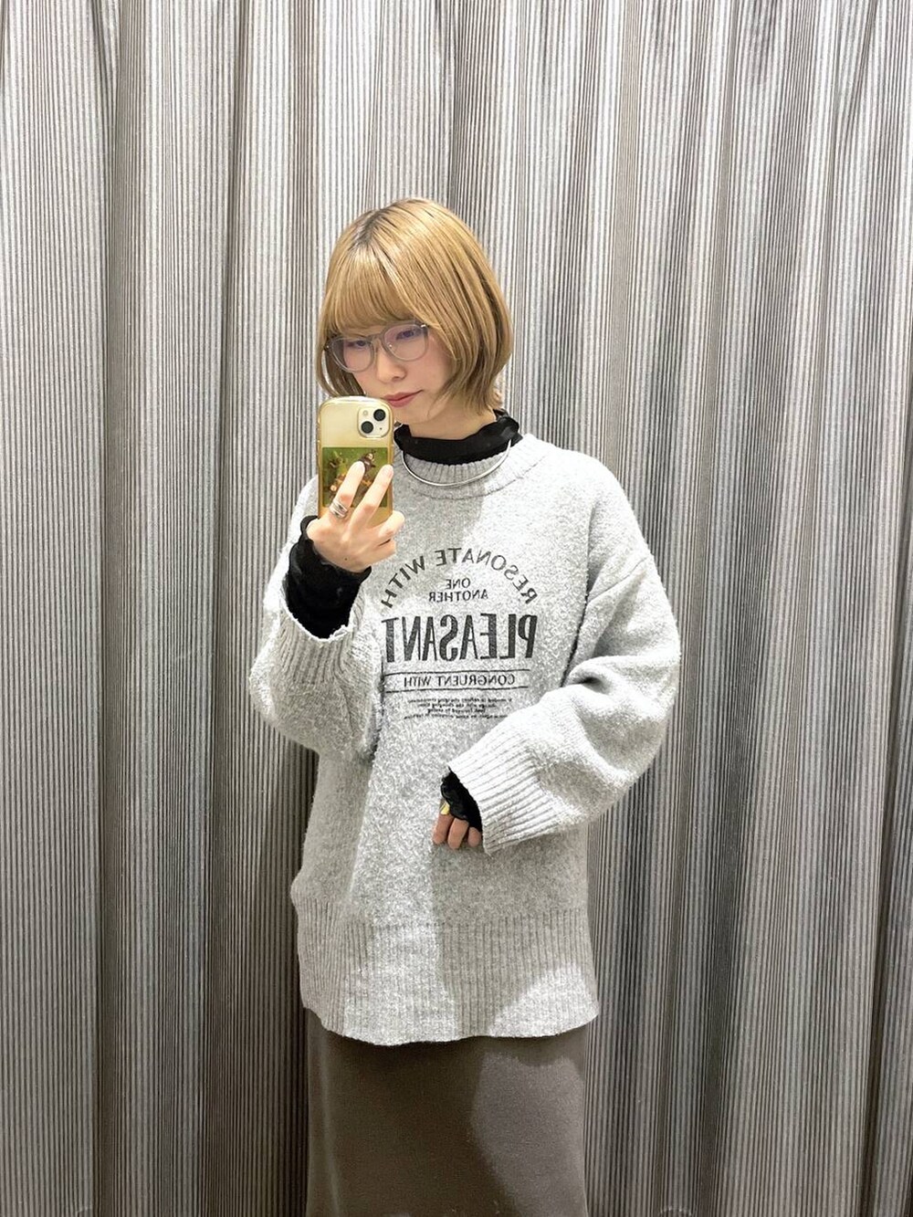 ブラック系のスニーカー、グレー系のスカート、グレー系のニット/セーターを着用したレディースの冬コーディネートの3枚目の写真