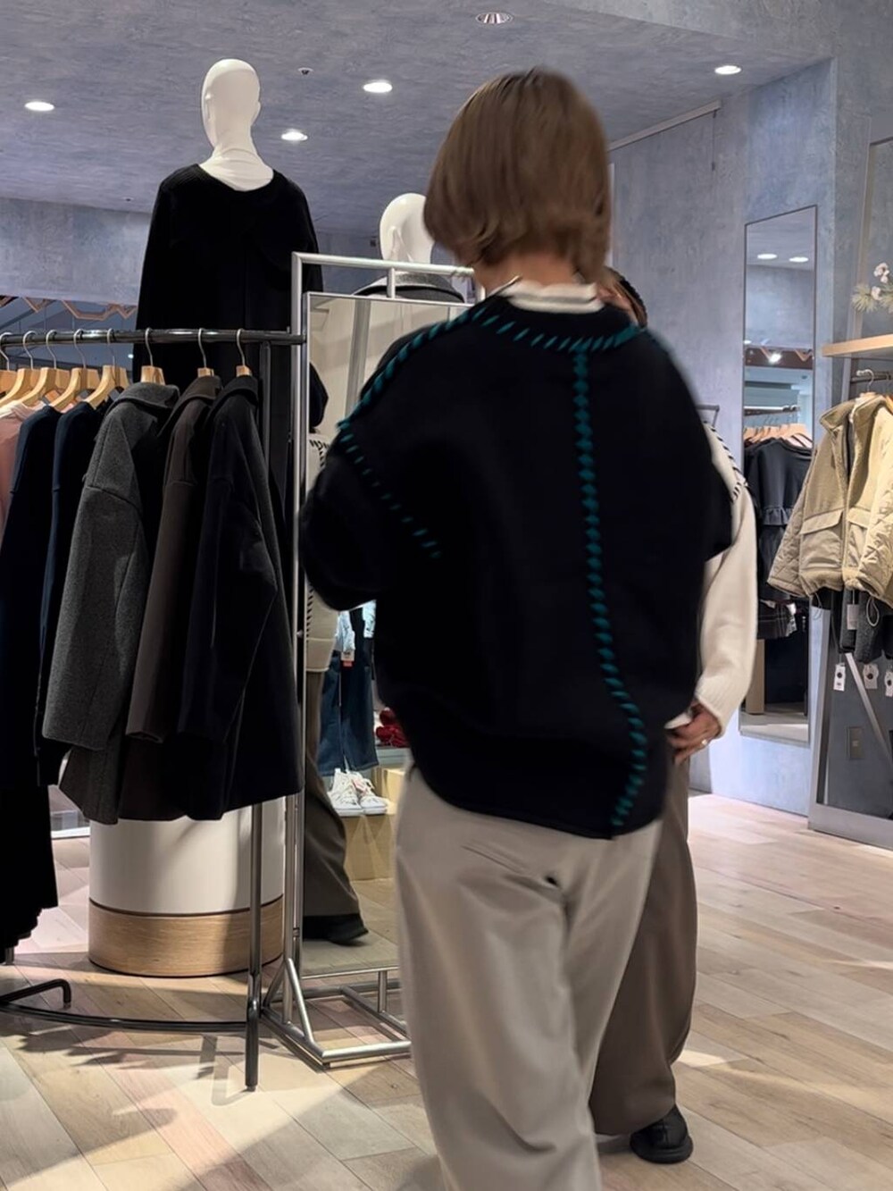 ブラック系のブーツ、ホワイト系のニット/セーター、ブラウン系のその他パンツを着用したレディースの冬コーディネートの2枚目の写真