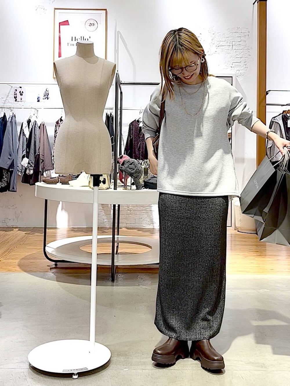 ブラウン系のブーツ、グレー系のTシャツ/カットソー、その他のスカートを着用したレディースの秋コーディネートの2枚目の写真