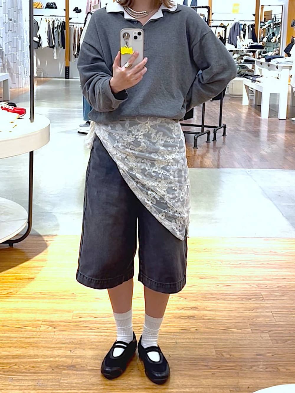 ブラック系のパンプス、ブラック系のデニムパンツ、グレー系のニット/セーターを着用したレディースの春コーディネートの2枚目の写真