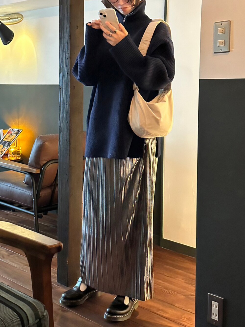 ブルー系のニット/セーター、グレー系のステンカラーコート、シルバー系のスカートを着用したレディースの冬コーディネートの2枚目の写真