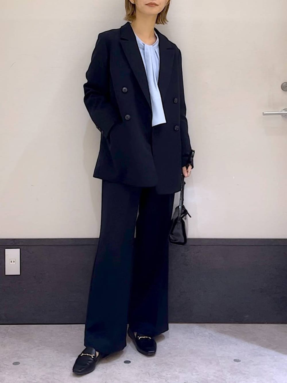 ブルー系のスーツパンツ、ブルー系のシャツ/ブラウス、ブラック系のローファーを着用したレディースの冬コーディネートの2枚目の写真