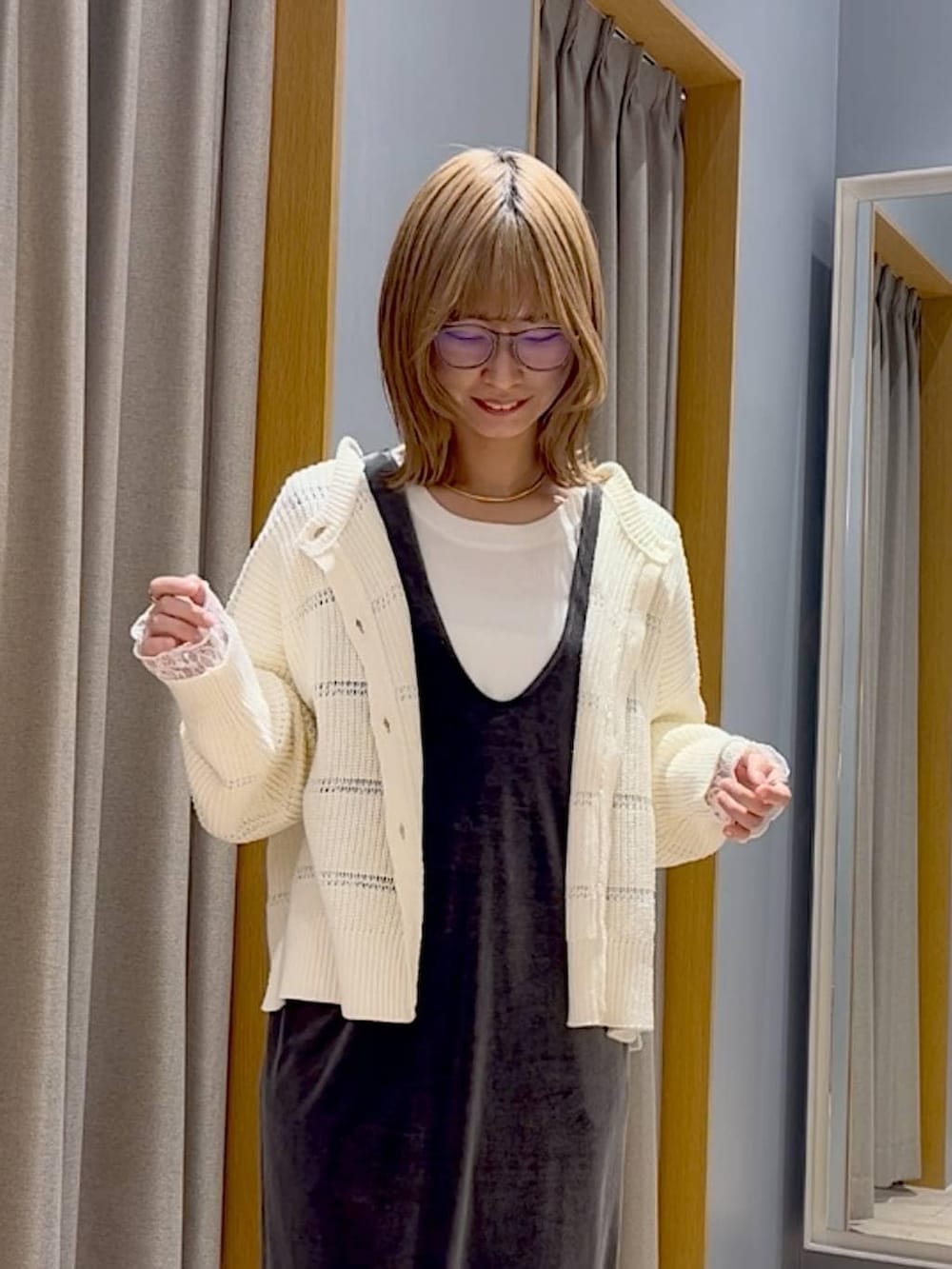 ブラック系のスニーカー、グレー系のジャンパースカート、ゴールド系のチョーカーを着用したレディースの冬コーディネートの3枚目の写真