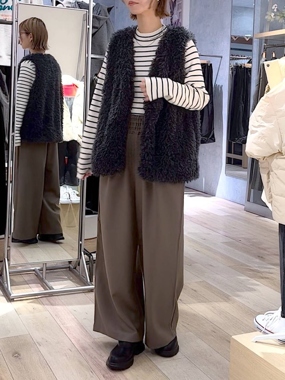 ブラウン系のその他パンツ、ブラック系のブーツ、ホワイト系のニット/セーターを着用したレディースの秋コーディネートの2枚目の写真