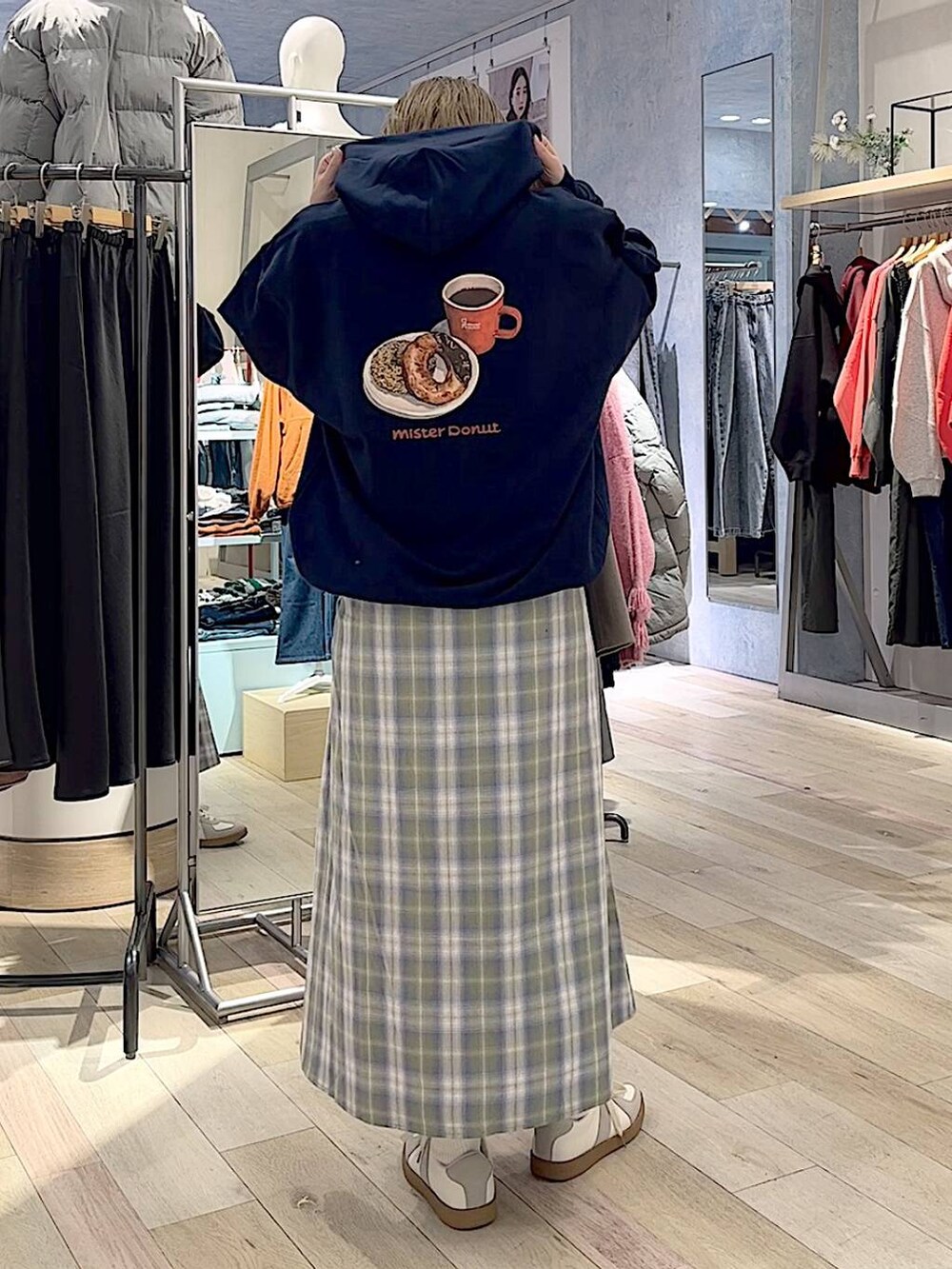 グリーン系のスカート、ホワイト系のスニーカー、ブルー系のパーカーを着用したレディースの冬コーディネートの3枚目の写真