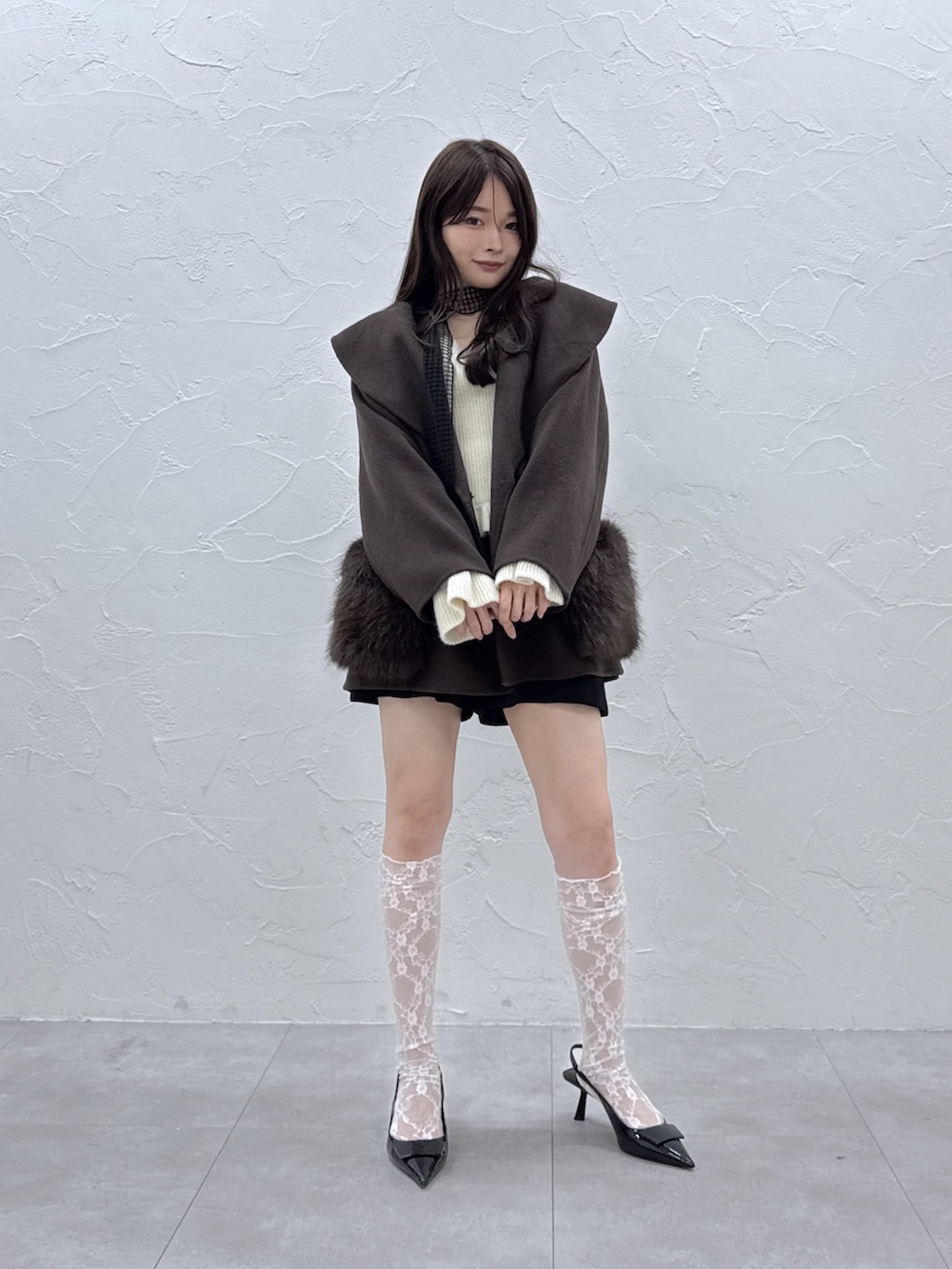 ブラウン系のその他アウター、ブラック系のその他パンツ、ホワイト系のニット/セーターを着用したレディースの秋コーディネートの4枚目の写真