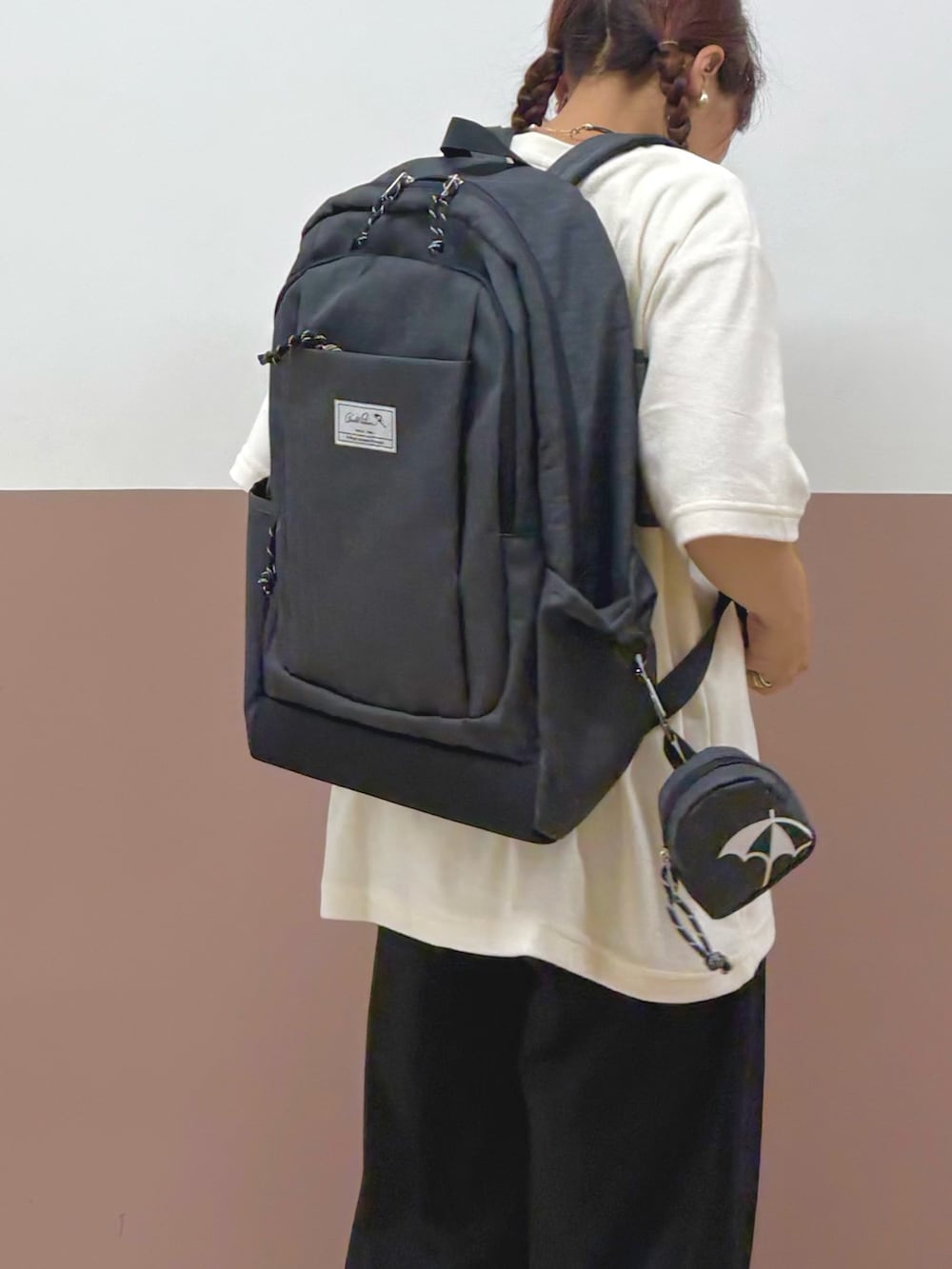 ホワイト系のTシャツ/カットソー、グレー系のバックパック/リュック、ブラック系のその他パンツを着用したレディースの夏コーディネートの2枚目の写真