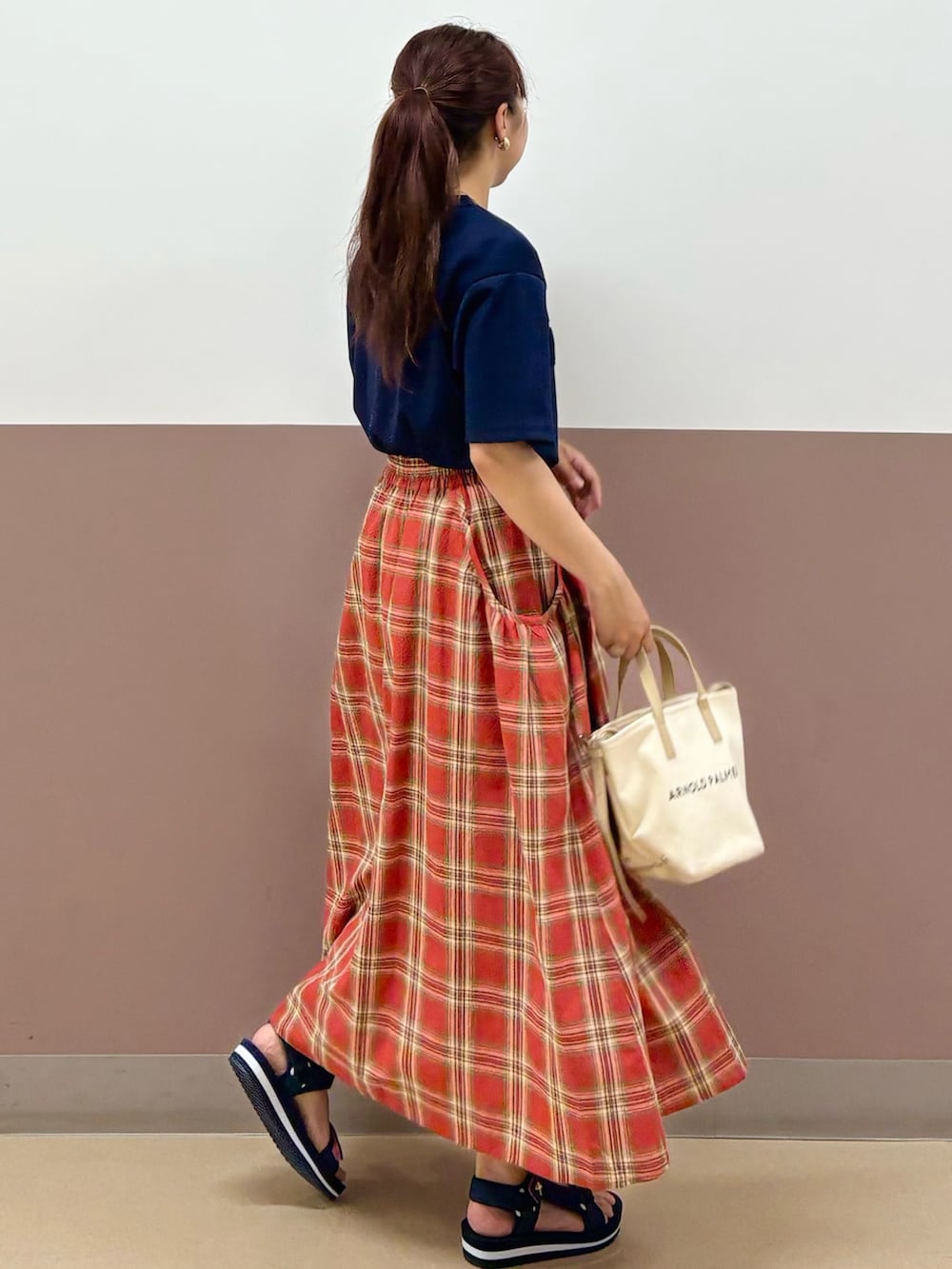 ブルー系のTシャツ/カットソー、レッド系のスカート、ブルー系のサンダルを着用したレディースの夏コーディネートの2枚目の写真