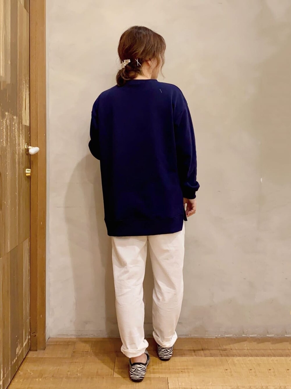 ホワイト系のデニムパンツ、ブラック系のパンプスを着用したレディースの冬コーディネートの3枚目の写真