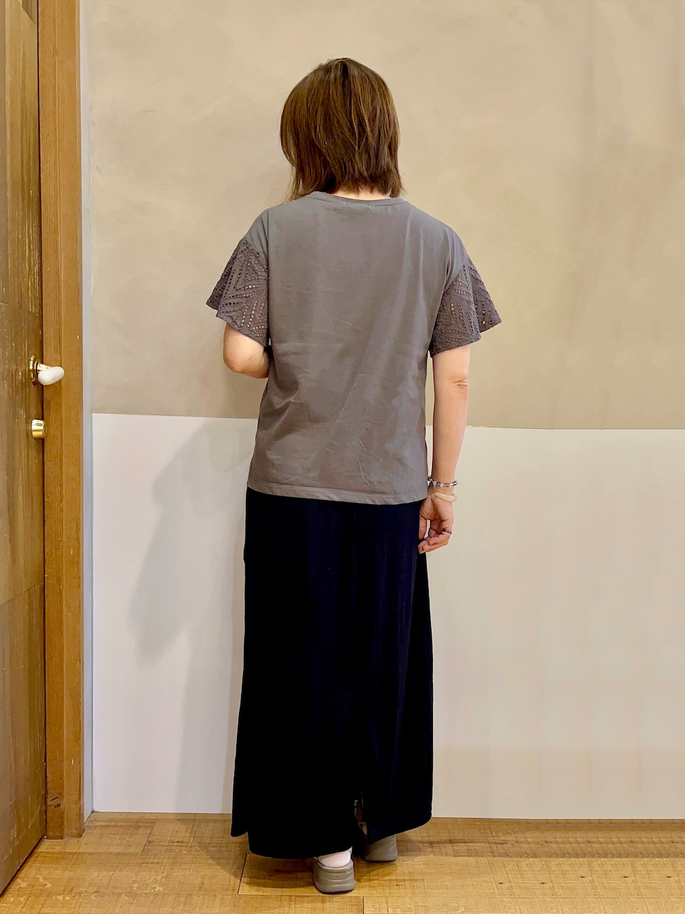 グレー系のTシャツ/カットソー、ブラック系のスカート、ブラウン系のサンダルを着用したレディースの夏コーディネートの3枚目の写真