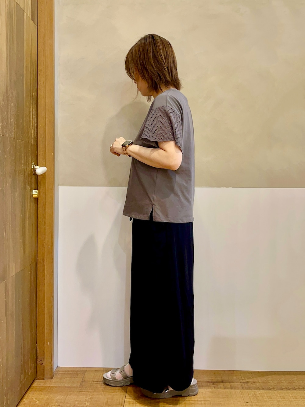 グレー系のTシャツ/カットソー、ブラック系のスカート、ブラウン系のサンダルを着用したレディースの夏コーディネートの2枚目の写真