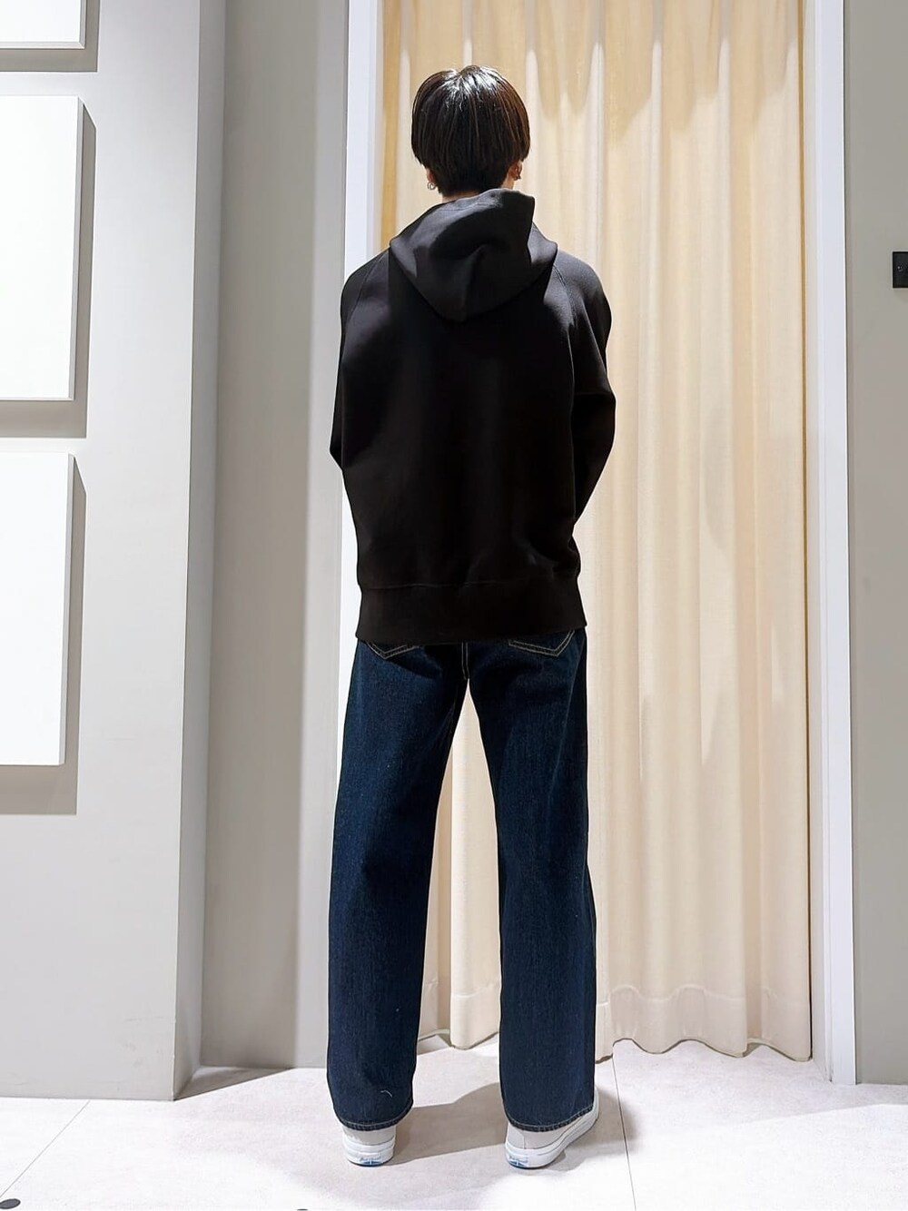 グレー系のスニーカー、ブルー系のその他パンツ、ブラック系のパーカーを着用したメンズの秋コーディネートの3枚目の写真