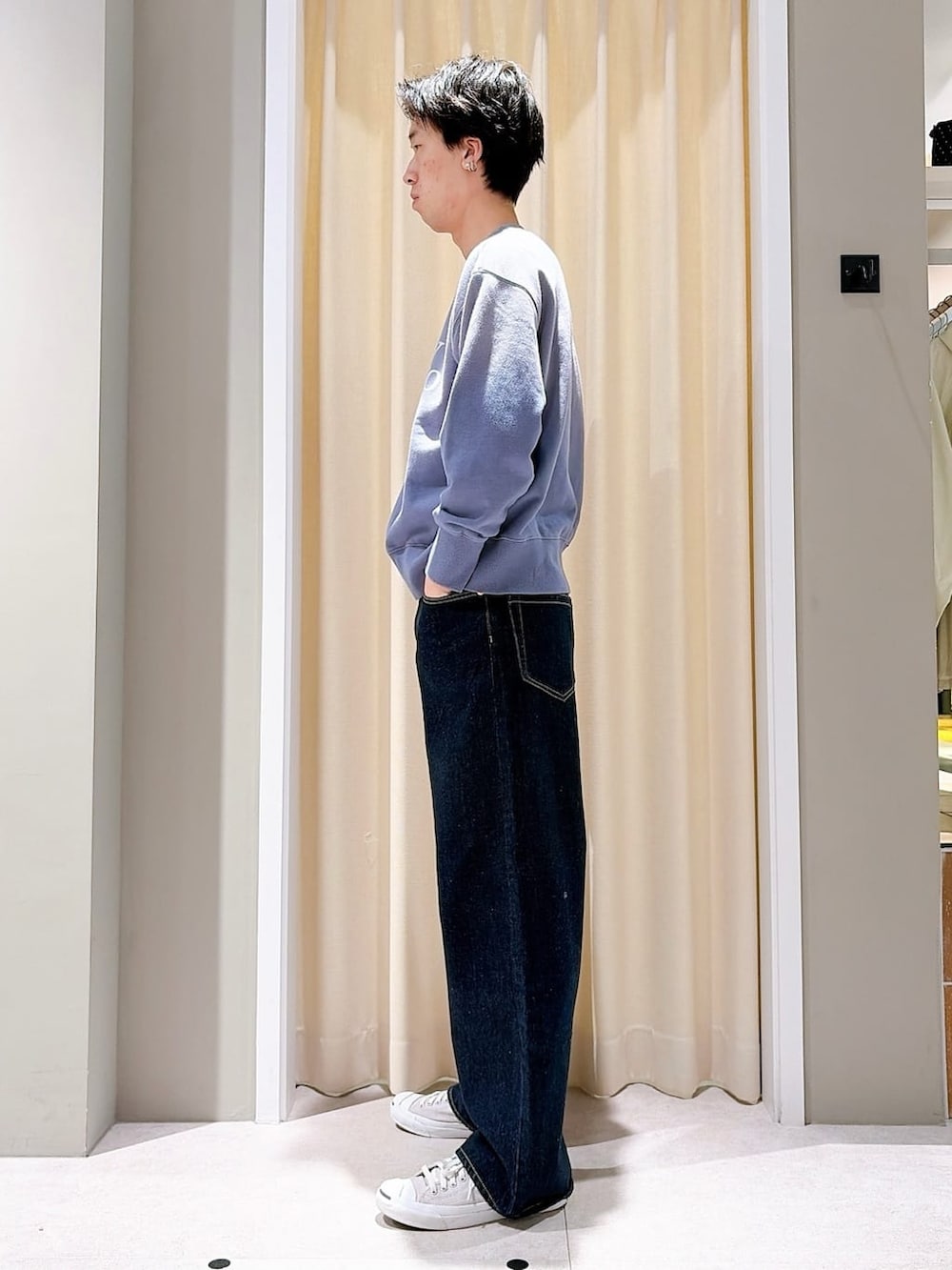 グレー系のスニーカー、ブルー系のデニムパンツ、ブルー系のスウェットを着用したメンズの春コーディネートの2枚目の写真